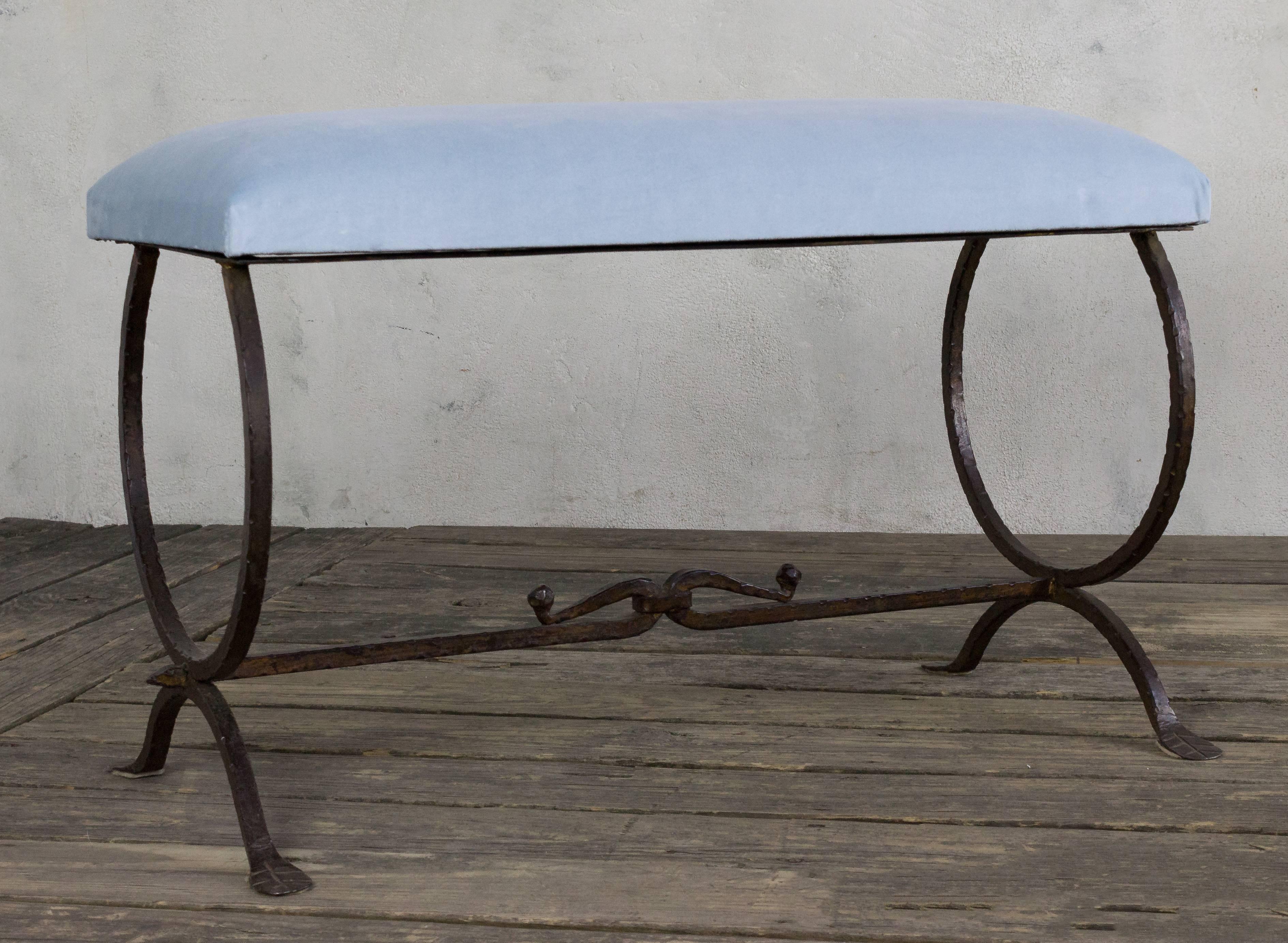 Beautiful wrought iron bench with a circular motif legs and a detailed stretcher.
      