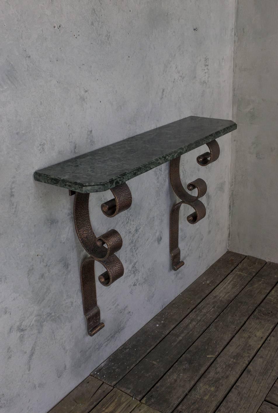 Unusual wall-mounted console with double scrolled supports in hammered copper-plated iron. The green marble-top has distinctive veining, French, circa 1930.