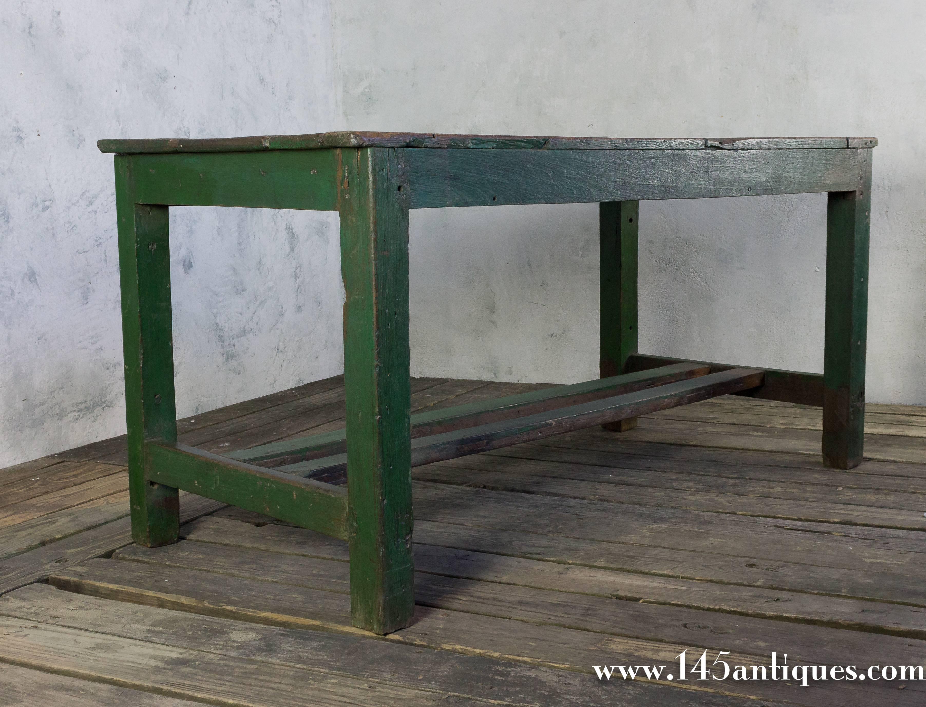 French Industrial wooden work table with old green paint patina on the legs and a natural wooden top, early 20th century.