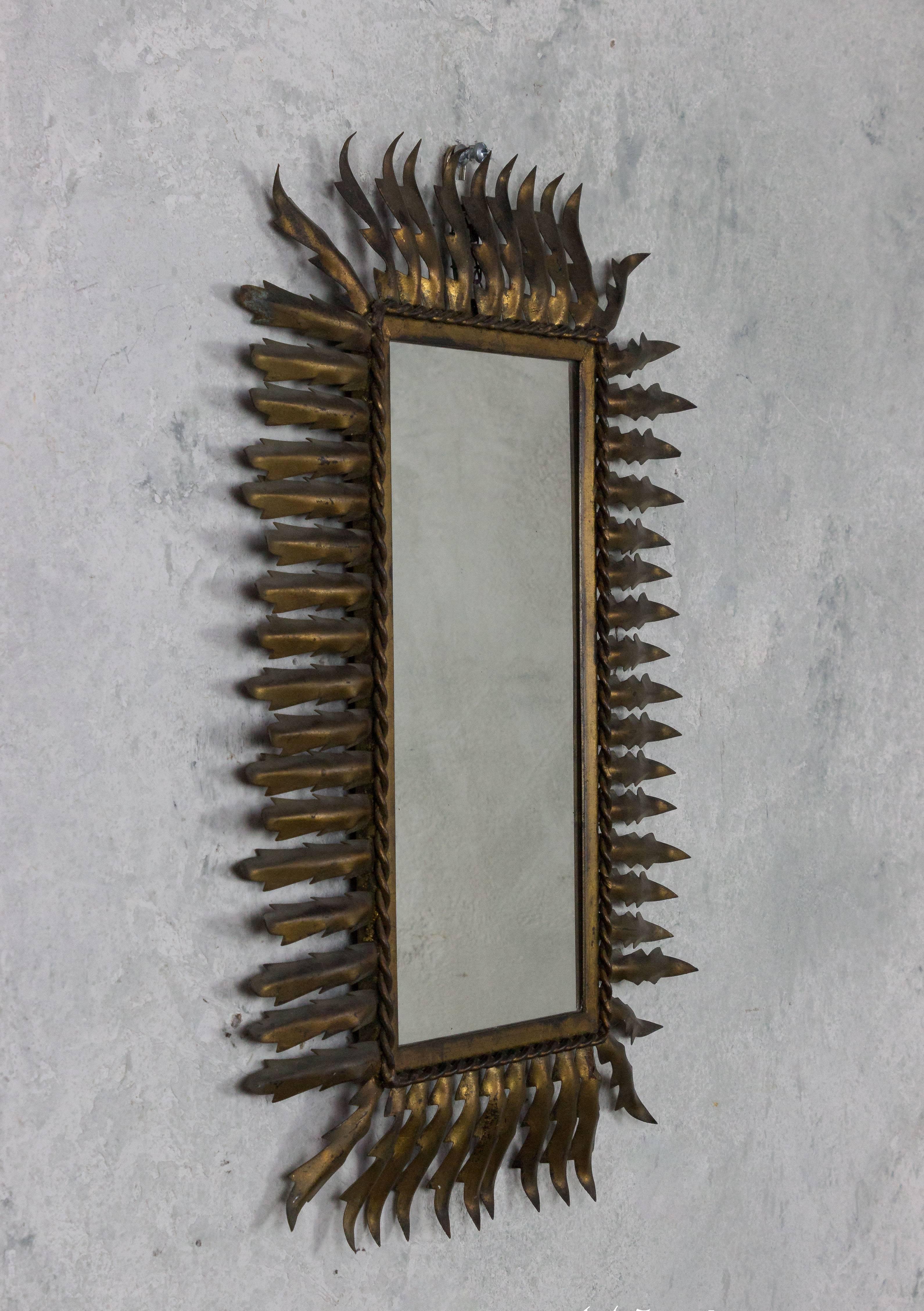Unusual gilt metal sunburst style mirror in a rectangular shape.