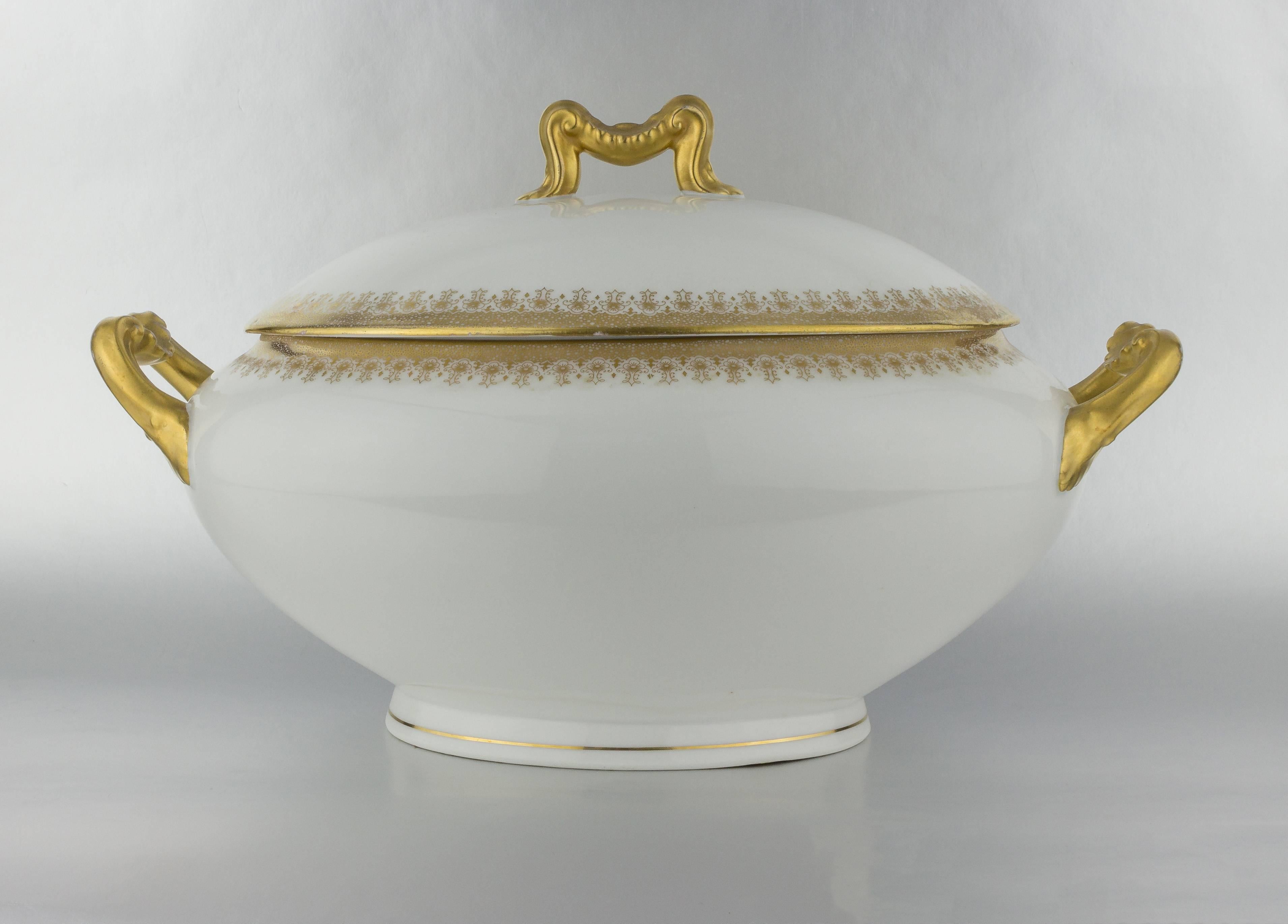 Porcelain covered tureen with gold detail and gilt handles.