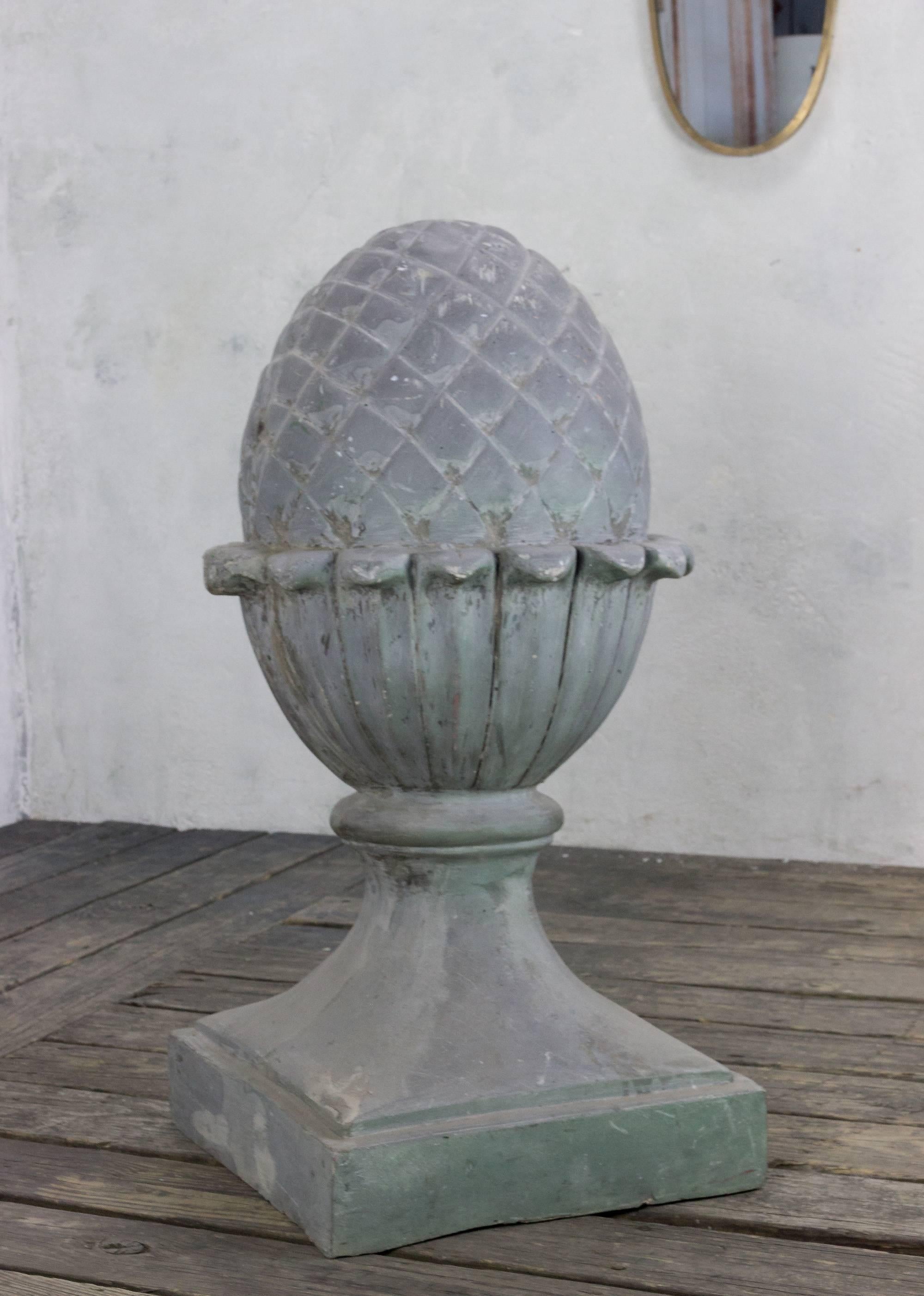 This fiberglass decoration in the shape of a pinecone is a truly interesting piece that is most likely a stage prop or a shop decoration. The piece is a beautiful representation of a stylized pinecone or acorn on a raised neoclassical base. Its