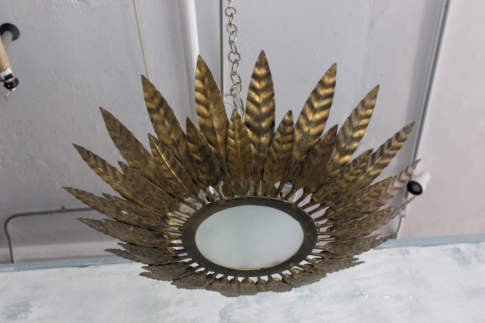 A spectacular Spanish 1950s gilt metal ceiling fixture with a double layer of leaf motifs. This gilt metal ceiling fixture is truly eye-catching. It boasts a double layer of small and large alternating and partially overlapping leaf motifs, creating