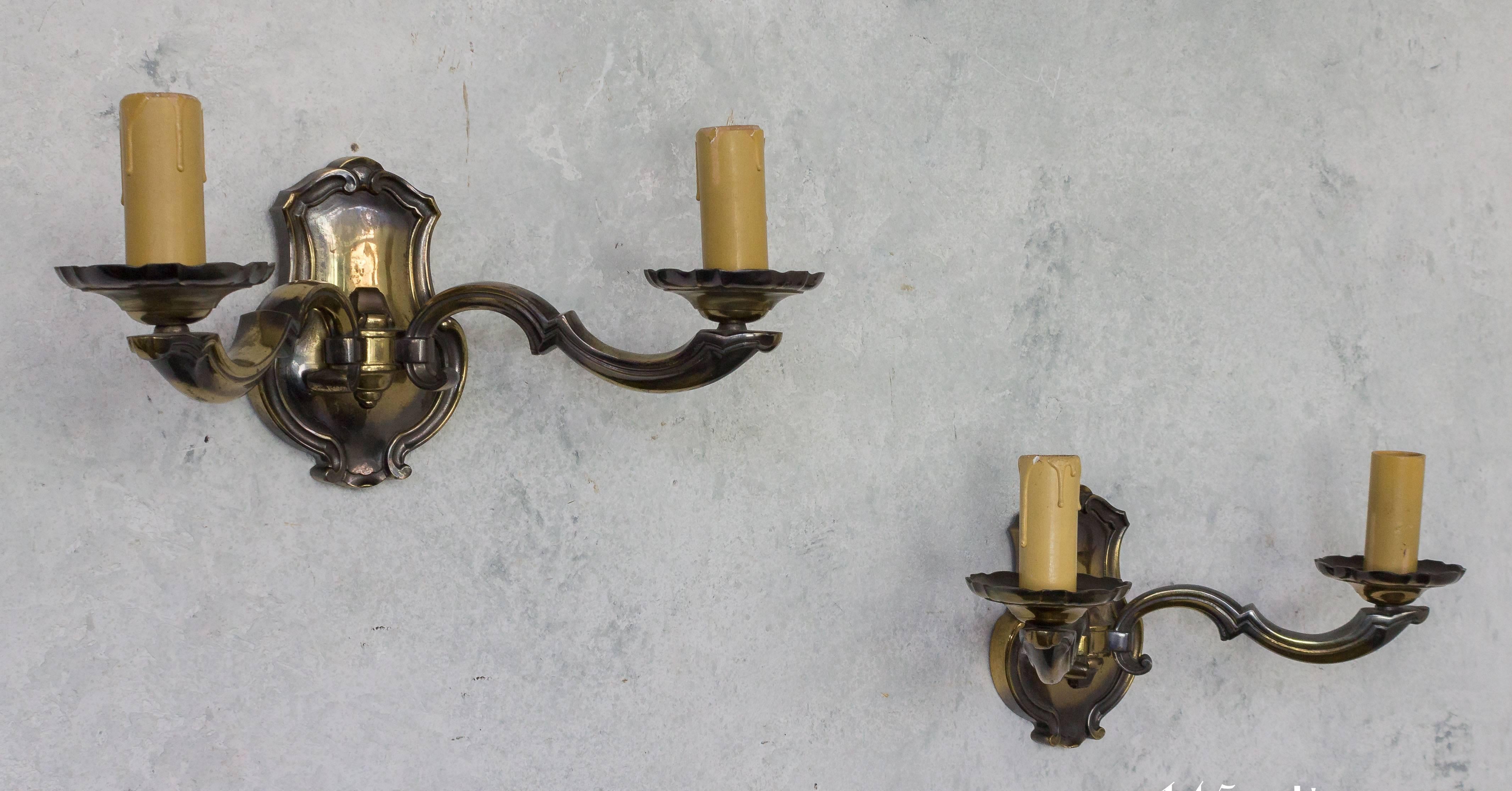 Dieses attraktive Paar französischer Wandleuchter aus den 1940er Jahren ist aus patinierter Bronze gefertigt, was ihnen einen einzigartigen Vintage-Charme verleiht. Die Qualität dieser Stücke ist bemerkenswert, und sie wurden im Laufe der Jahre gut