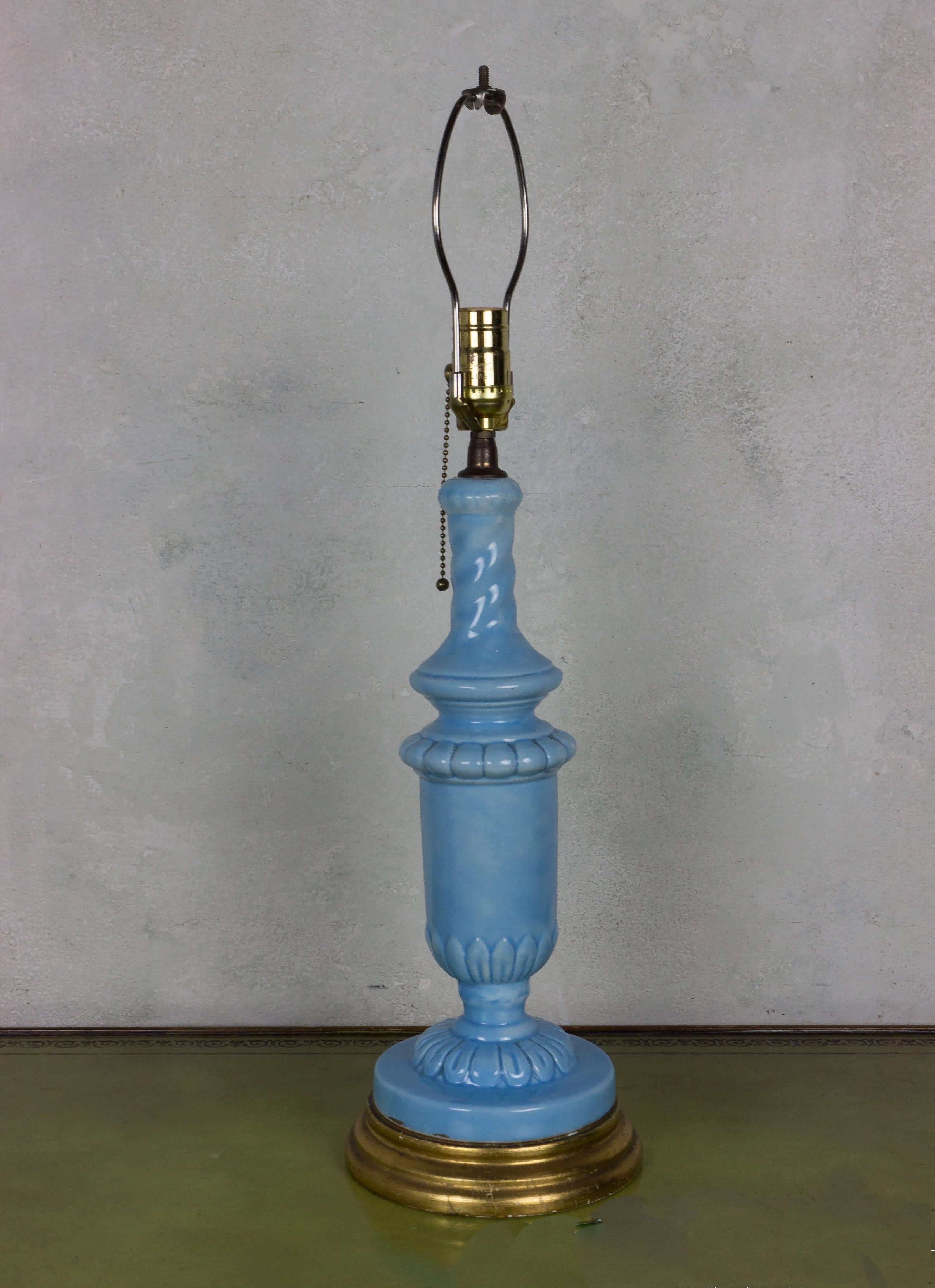 This stunning Spanish 1950s periwinkle blue ceramic table lamp with the original giltwood base is a rare find for those looking to add a touch of vintage sophistication to their home decor. Expertly crafted and recently rewired, although not UL
