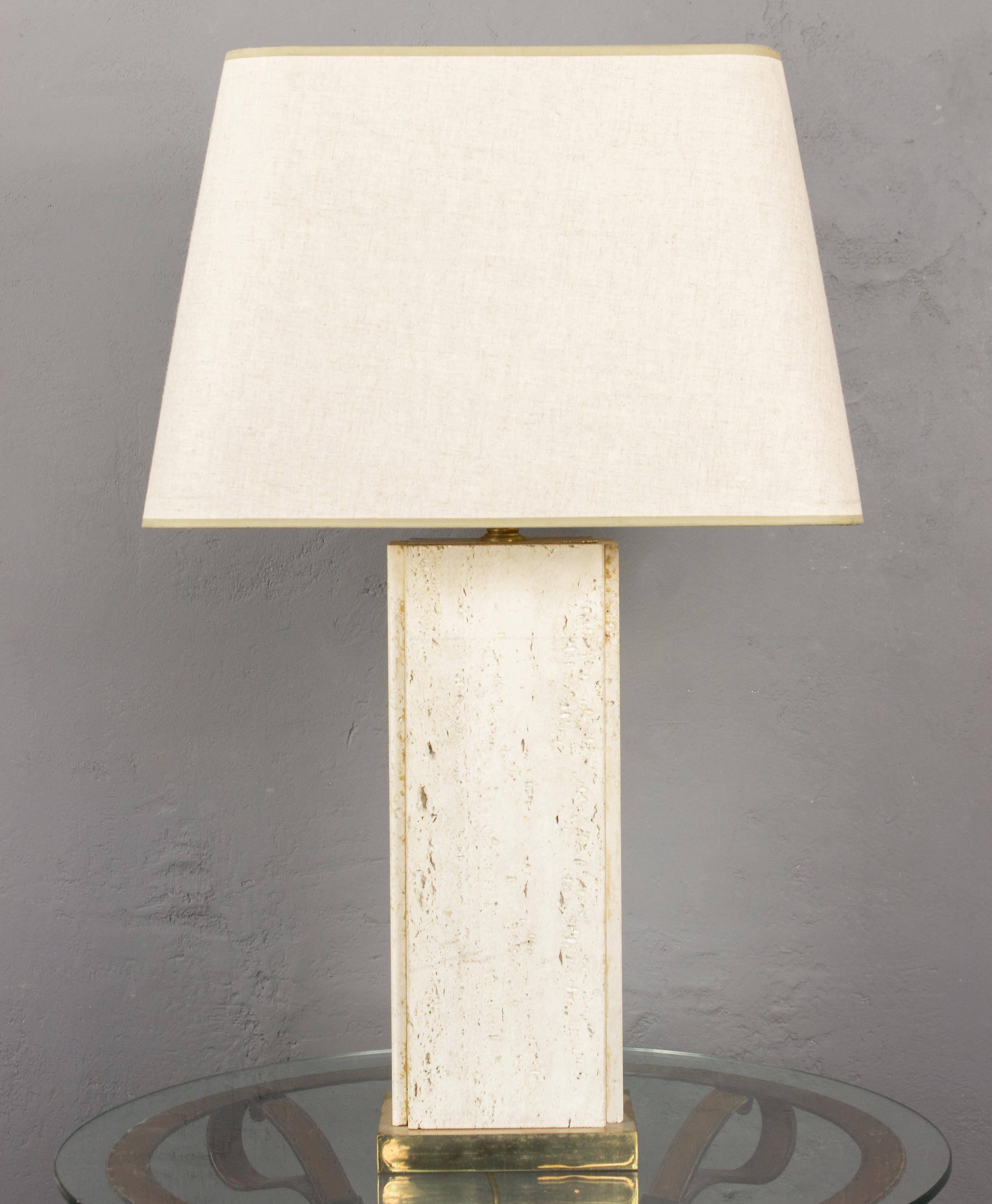 This remarkable French lamp from the mid-20th century features a large and impressive rectangular porous travertine body resting on a rectangular brass base. This unique piece has recently been rewired, ensuring its functionality and safety. The