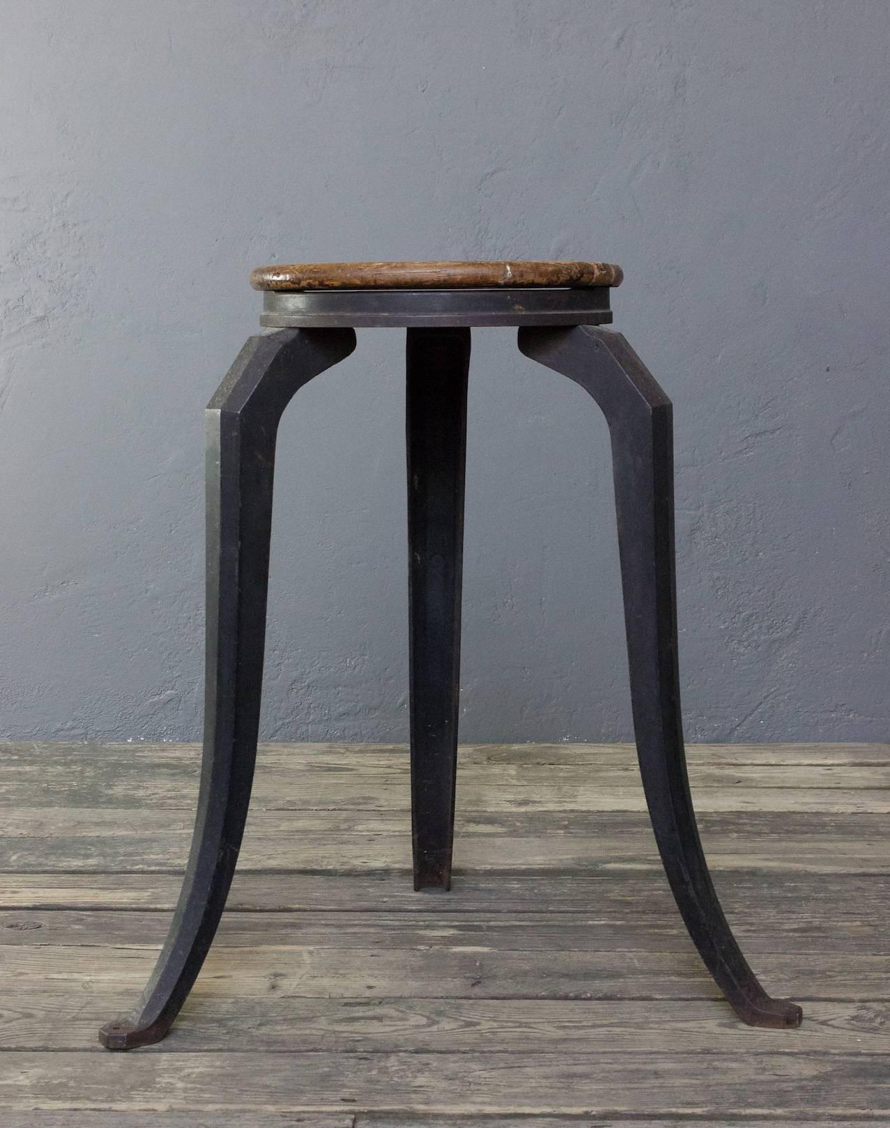 An industrial stool or pedestal with a cast iron base and a turned wooden top. Add a touch of vintage industrial to your home with this incredible cast iron stool. Originally used as a support for machinery, the base has since been fitted with an