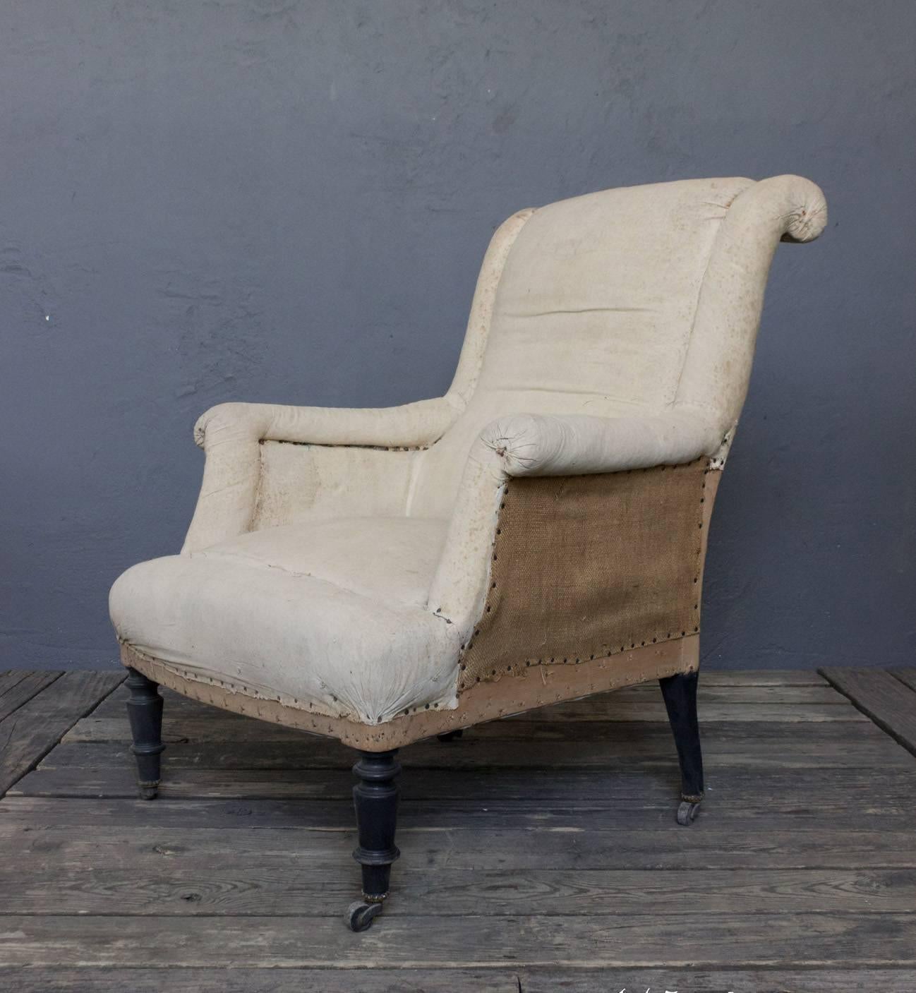 19th century pair of scrolled back armchairs with turned legs on casters.