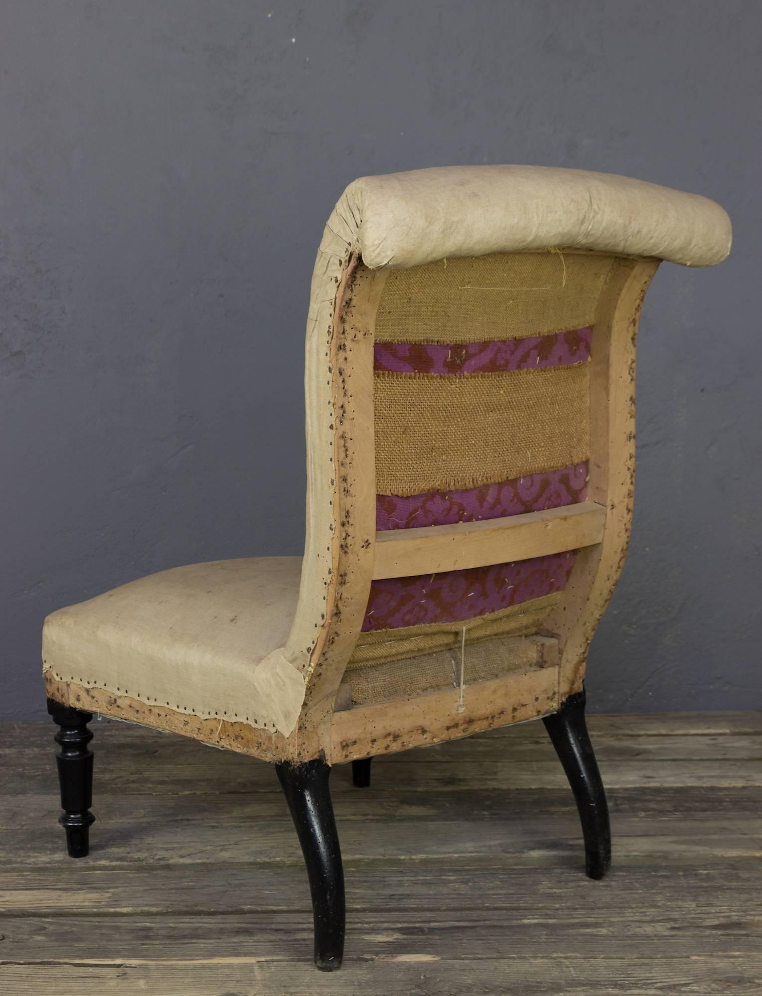 Elegant French slipper chair from the 19th century, the Napoleon III period. It has a rolled back with a tapered seat and back. Sold in aged muslin.