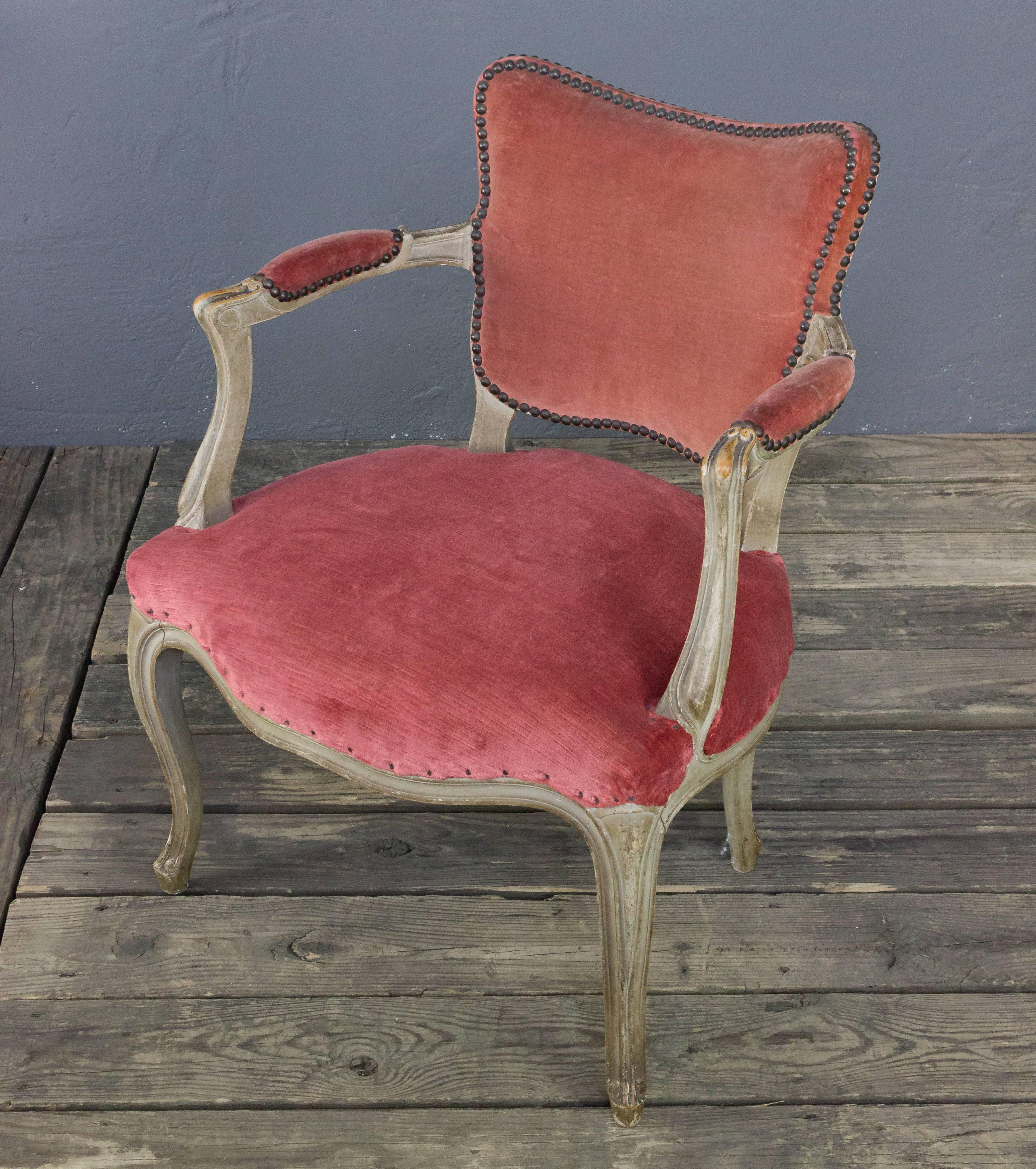 French, Louis XV style armchair upholstered in faded red velvet with brass nailhead detail. Structurally in very good condition with aged patina to frame.

 