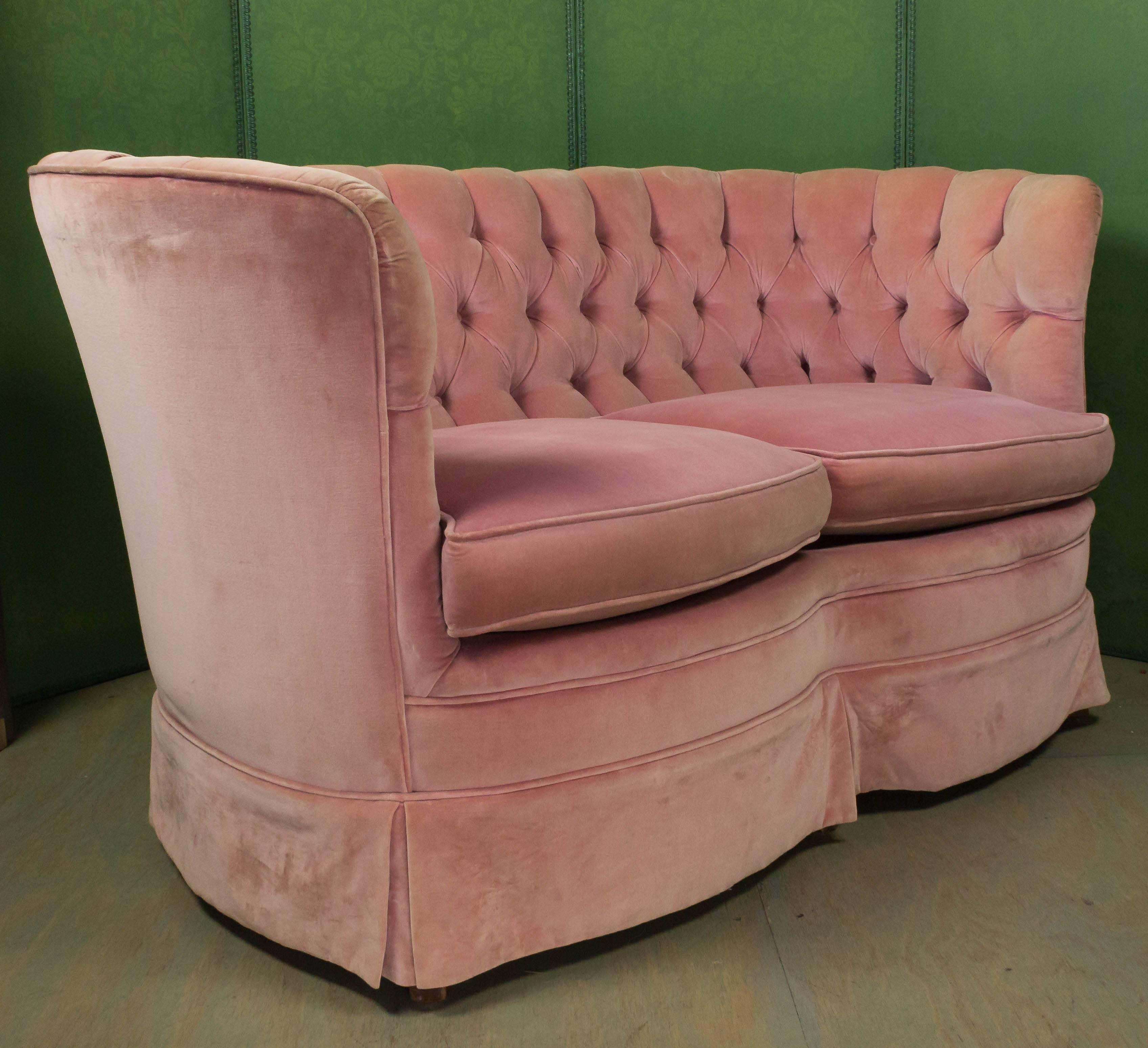 1940s curved tufted settee upholstered in soft pink velvet. The fabric shows signs of wear, but otherwise in good condition.  Sold as is. 


 