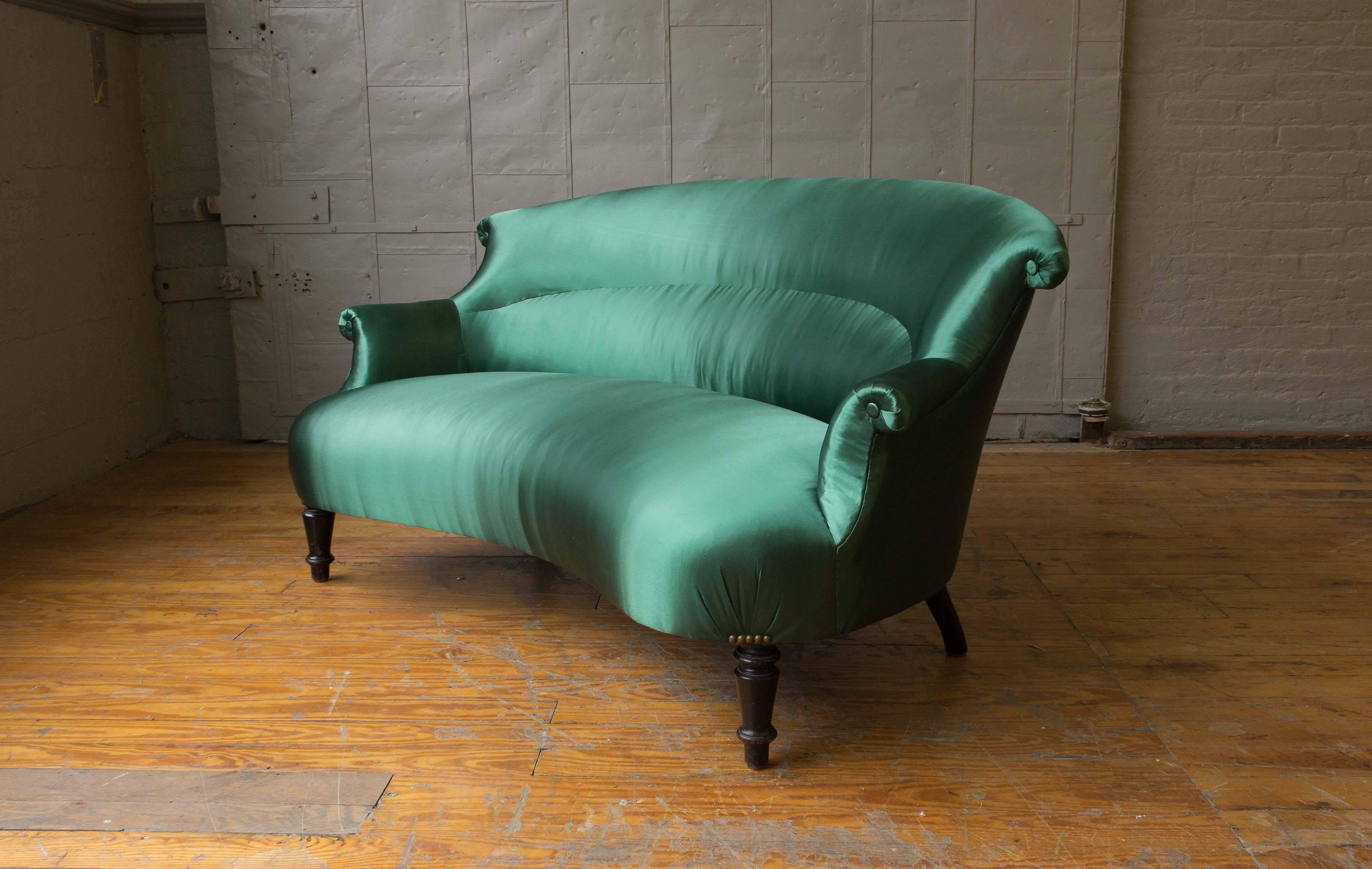Unusual French settee with scroll back. Upholstered in an emerald green satin.

  