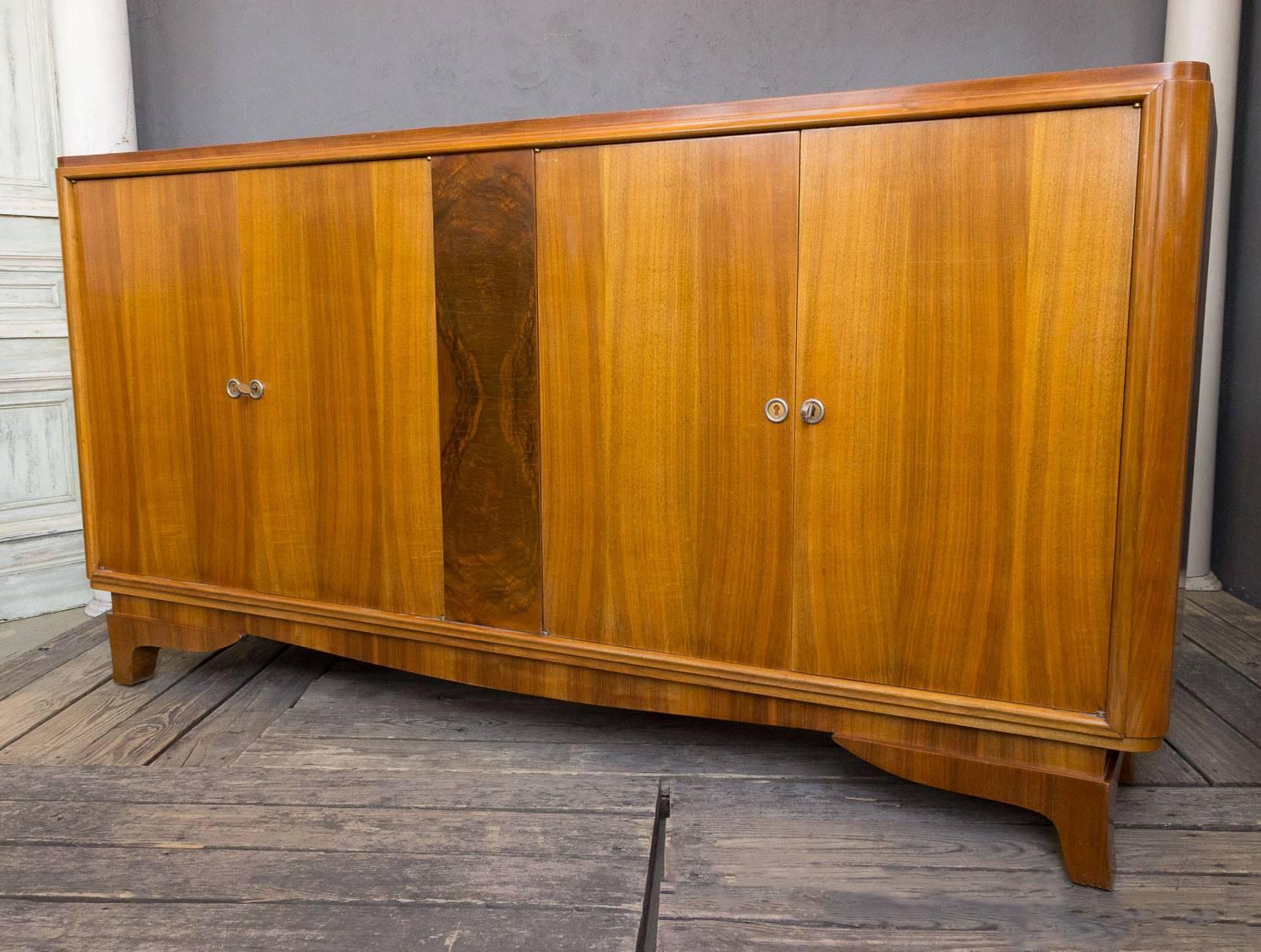 A large walnut sideboard with four doors, and center panel of burled wood. French 1940s. The sideboard is very well made and in good condition.

 