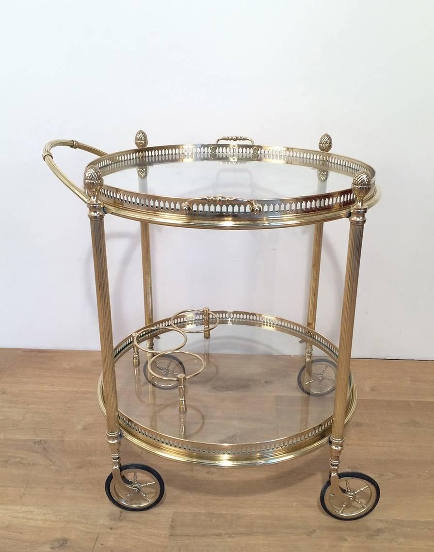 Small French brass and glass bar cart with a removable top tray with handles. The lower shelf has three compartments for bottles, circa 1960.

This item is currently in France, please allow 2 to 4 weeks delivery to New York. Shipping costs from