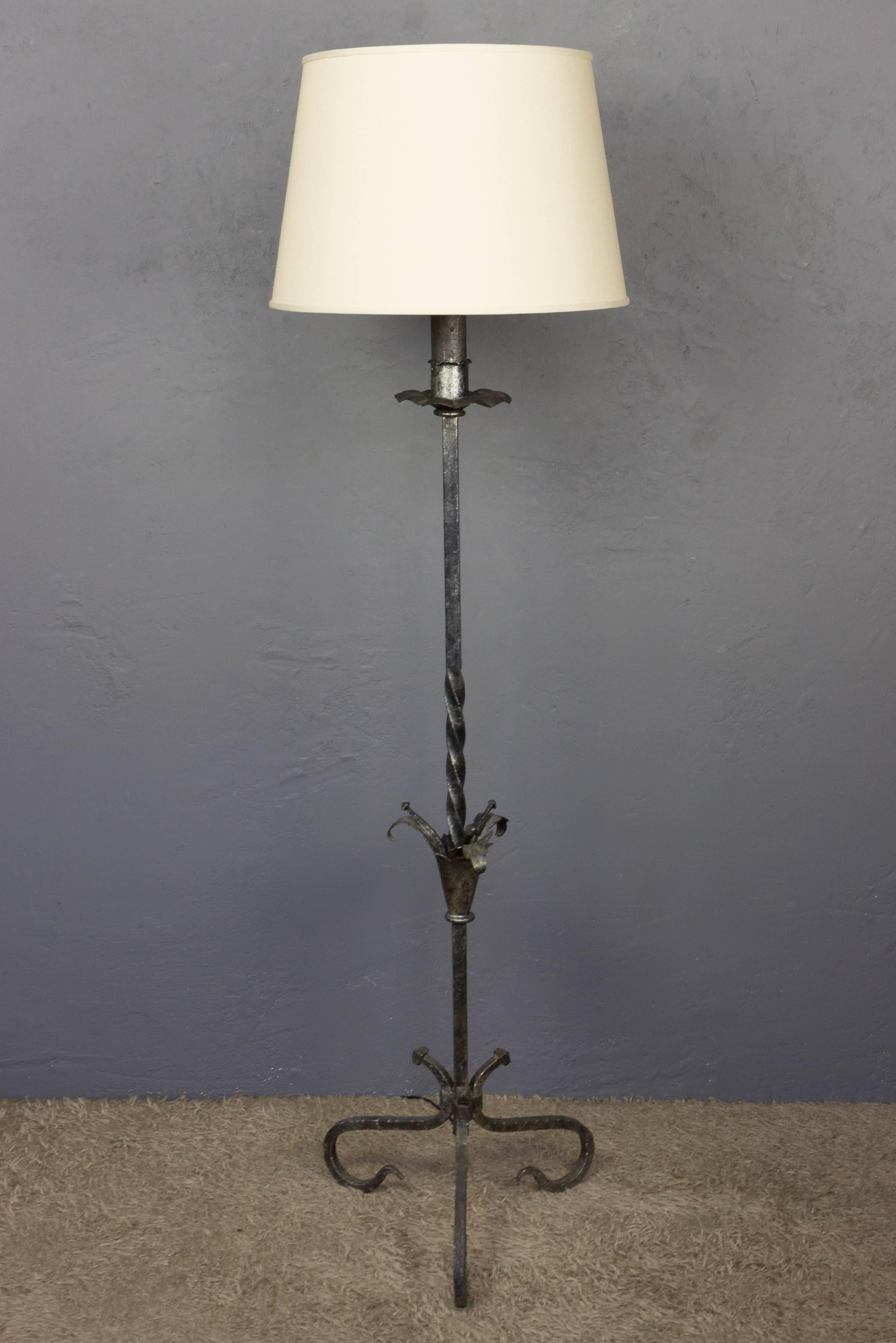 A captivating Spanish silvered iron floor lamp with a scrolled base. This unique piece, crafted in Spain during the 1950s, showcases unparalleled expertise and an exceptional design that will grace your space for years to come. The twisted stem