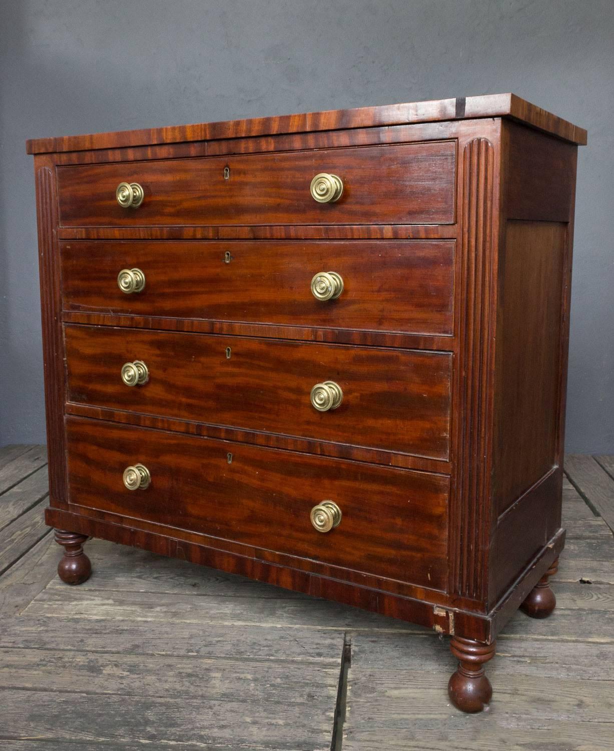English mahogany chest of drawers with ball feet and original hardware. The top of the piece has a cracked which can be repaired. Sold as is.