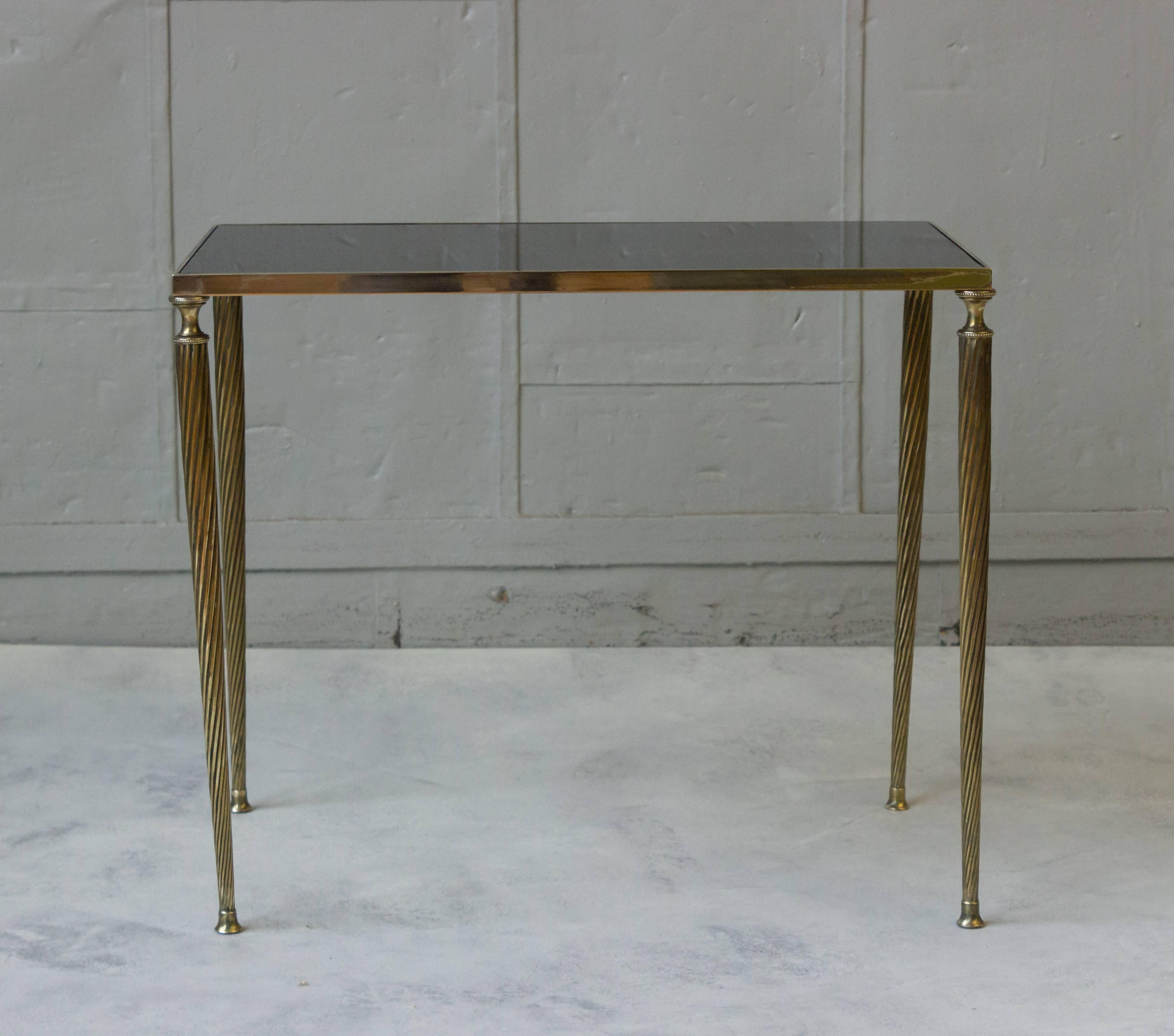 Set of three nesting tables with spiral turned brass legs and brass frames and black mirrored tops, French, 1940s in the style of Maison Jansen. The glass has been recently replaced.

 