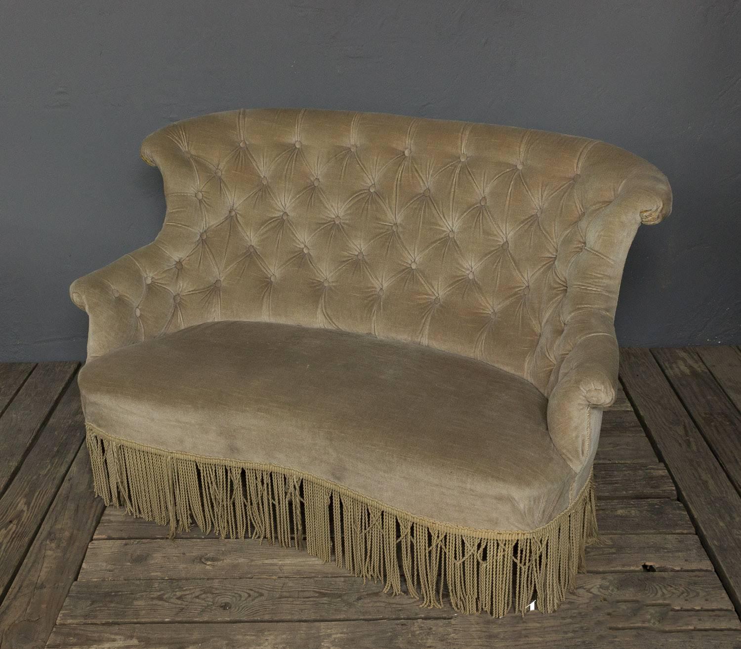 Originally part of a three-piece salon set, this wonderful tufted settee has a gracious scrolled back and rolled arms. The velvet has faded over the years to a warm sage green tone. Sold as is.