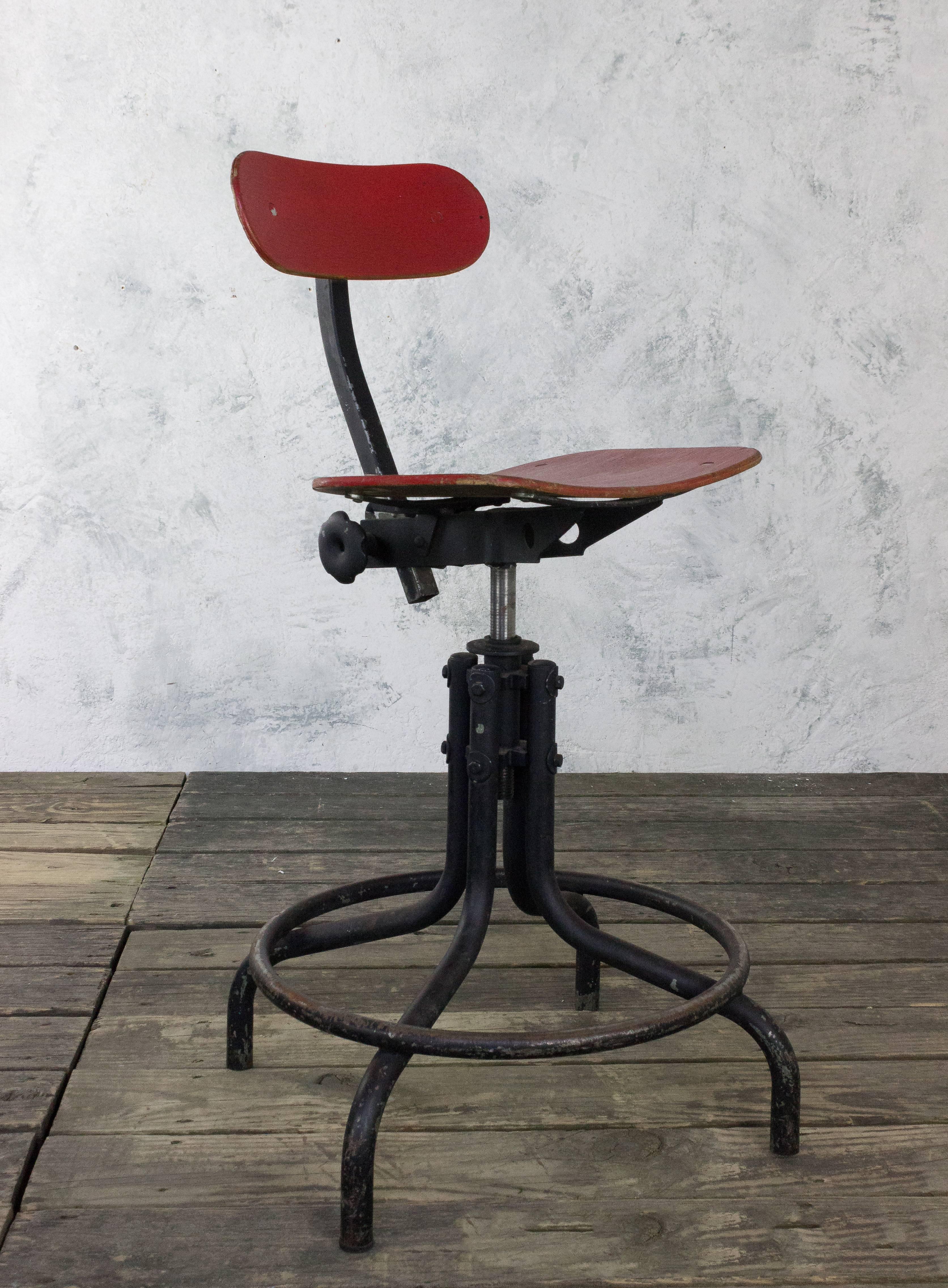 American 1950s red painted wood Industrial stool with black iron base and adjustable seat.

