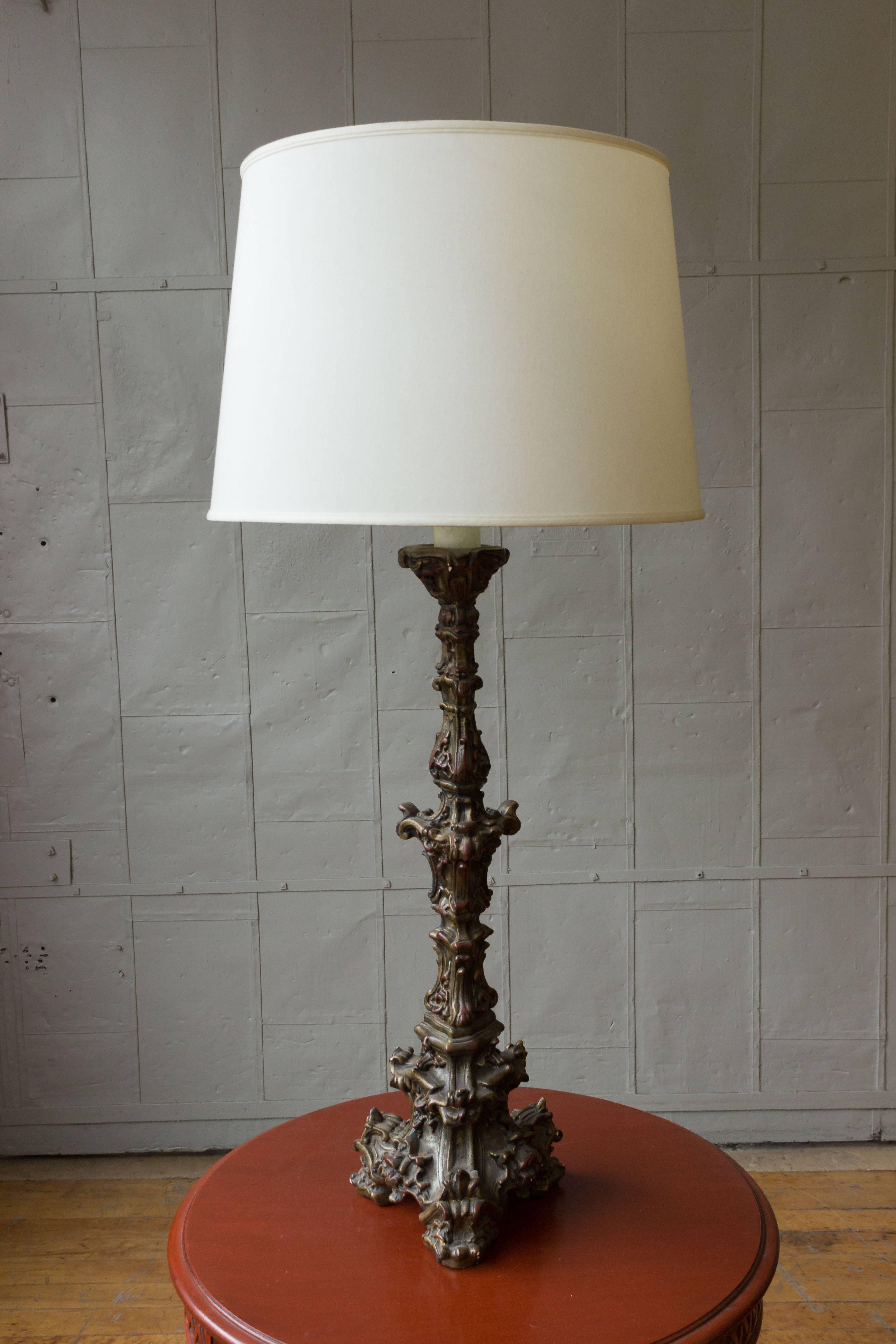 A unique pair of Italian mid century Neo-Baroque polyplaster table lamps in a dark bronze patina. These Neo-Baroque table lamps are an exquisite blend of vintage beauty and modern functionality. Standing tall at 45.5 inches in height, these