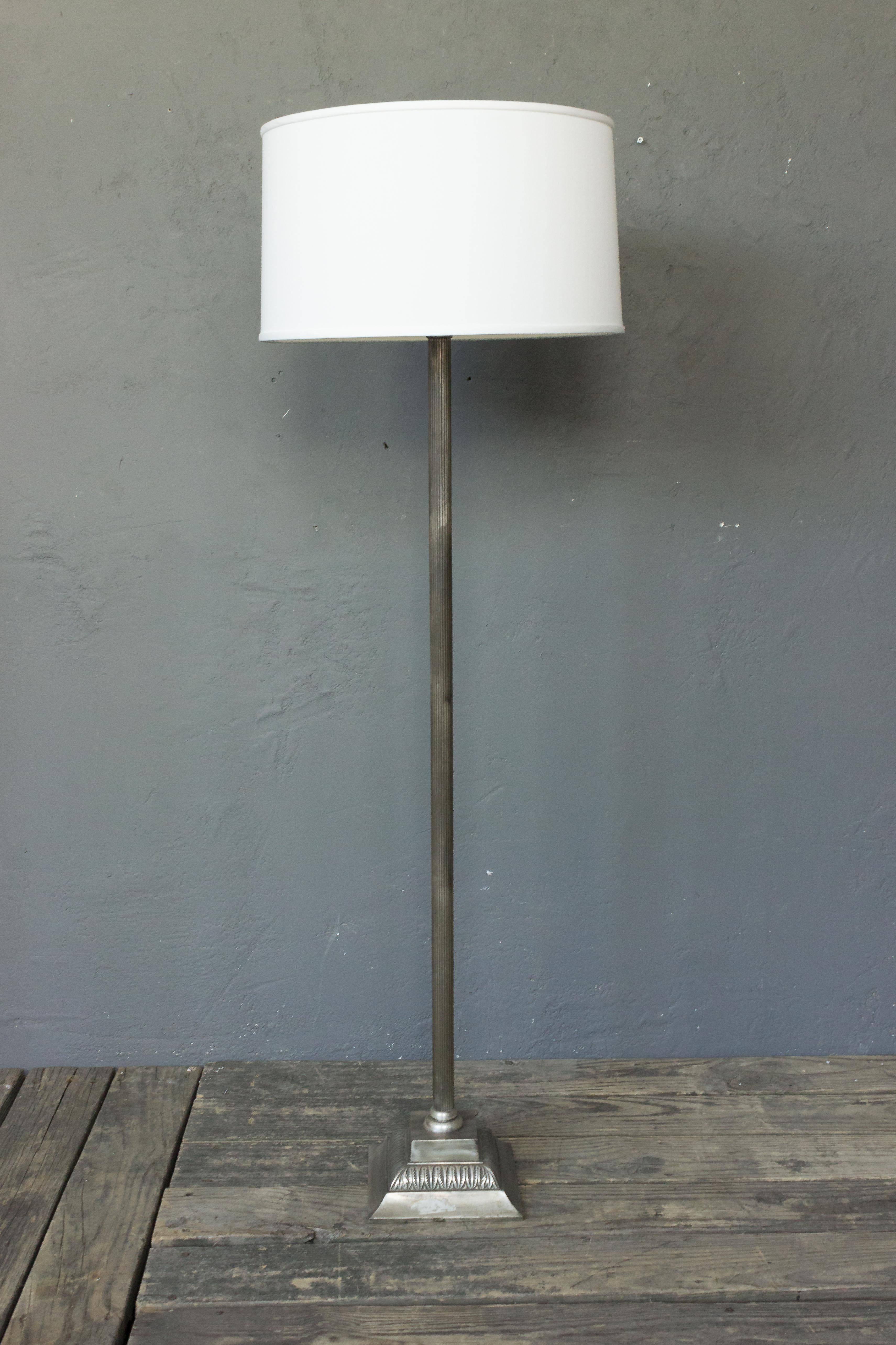 Presenting a French 1940s floor lamp made of silvered bronze and metal, resting on a neoclassical style square base. This remarkable piece is in good vintage condition, with wear consistent with age and use. The price includes hand polishing and new