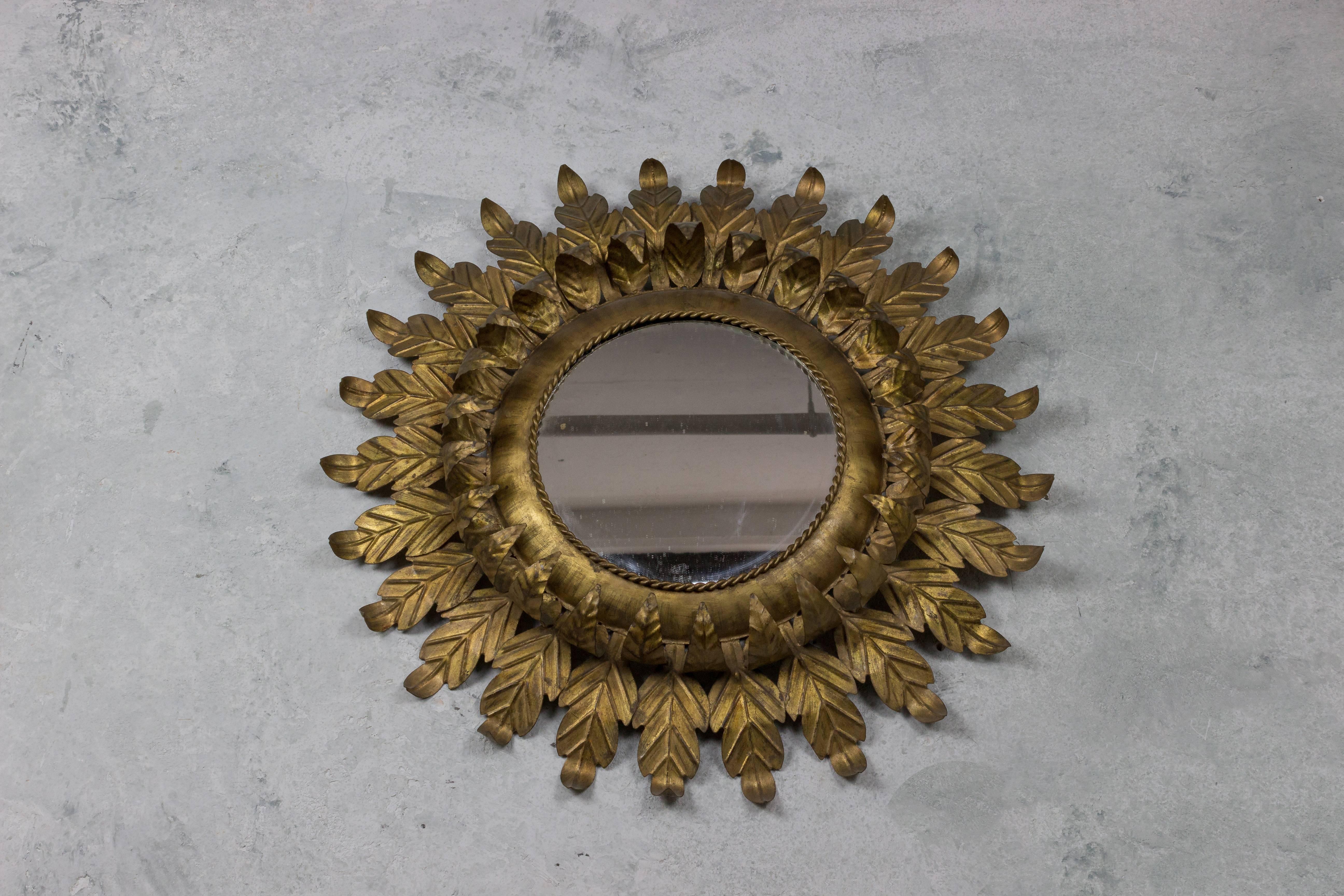 Elegant round sunburst mirror with delicate double leaf motif.