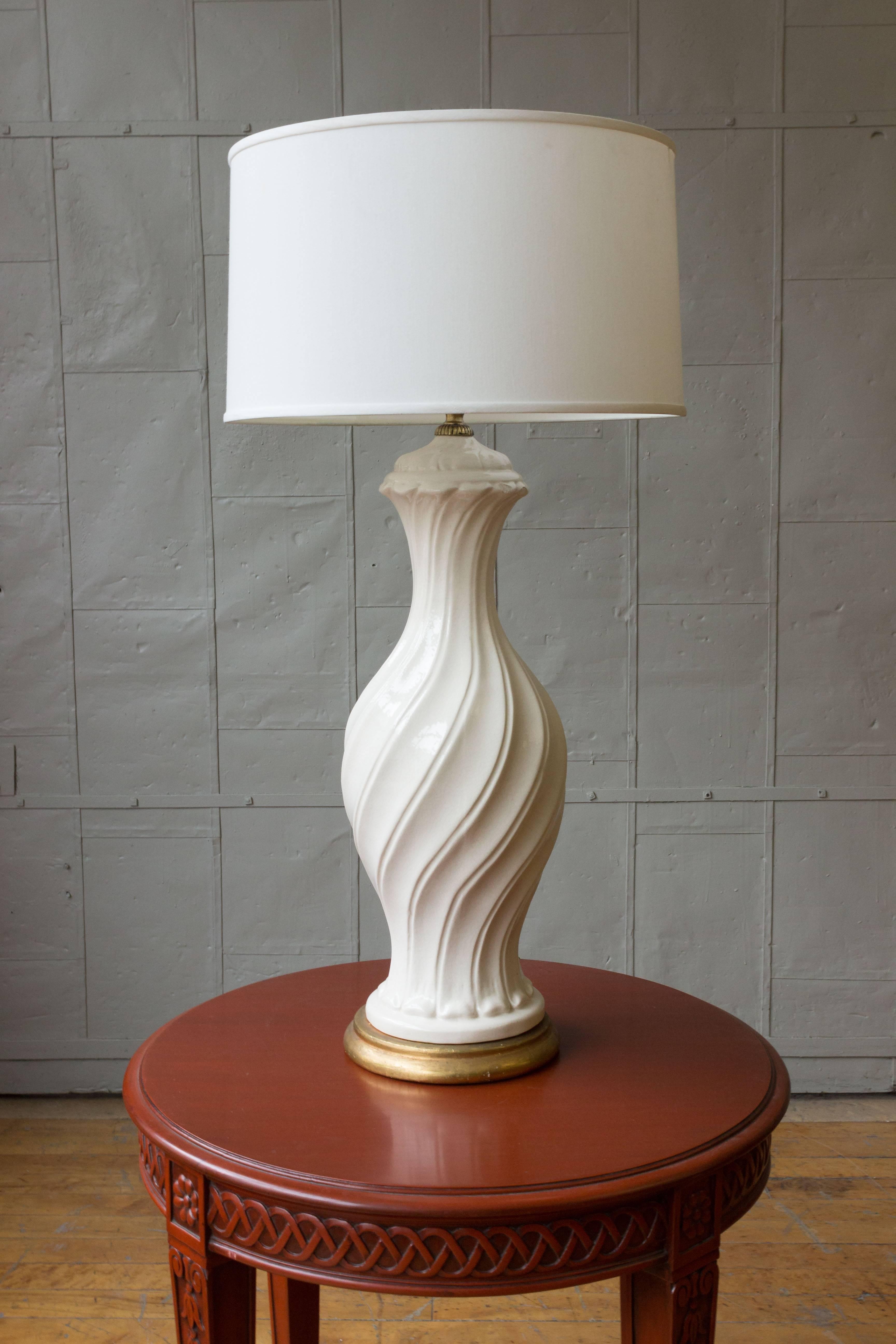 This Spanish 1950s oversized white ceramic lamp with crackle glaze and an antique gold base will bring a stylish and elegant look to any living space. With its size and lovely swirl design, this lamp is sure to make a statement. Despite being in