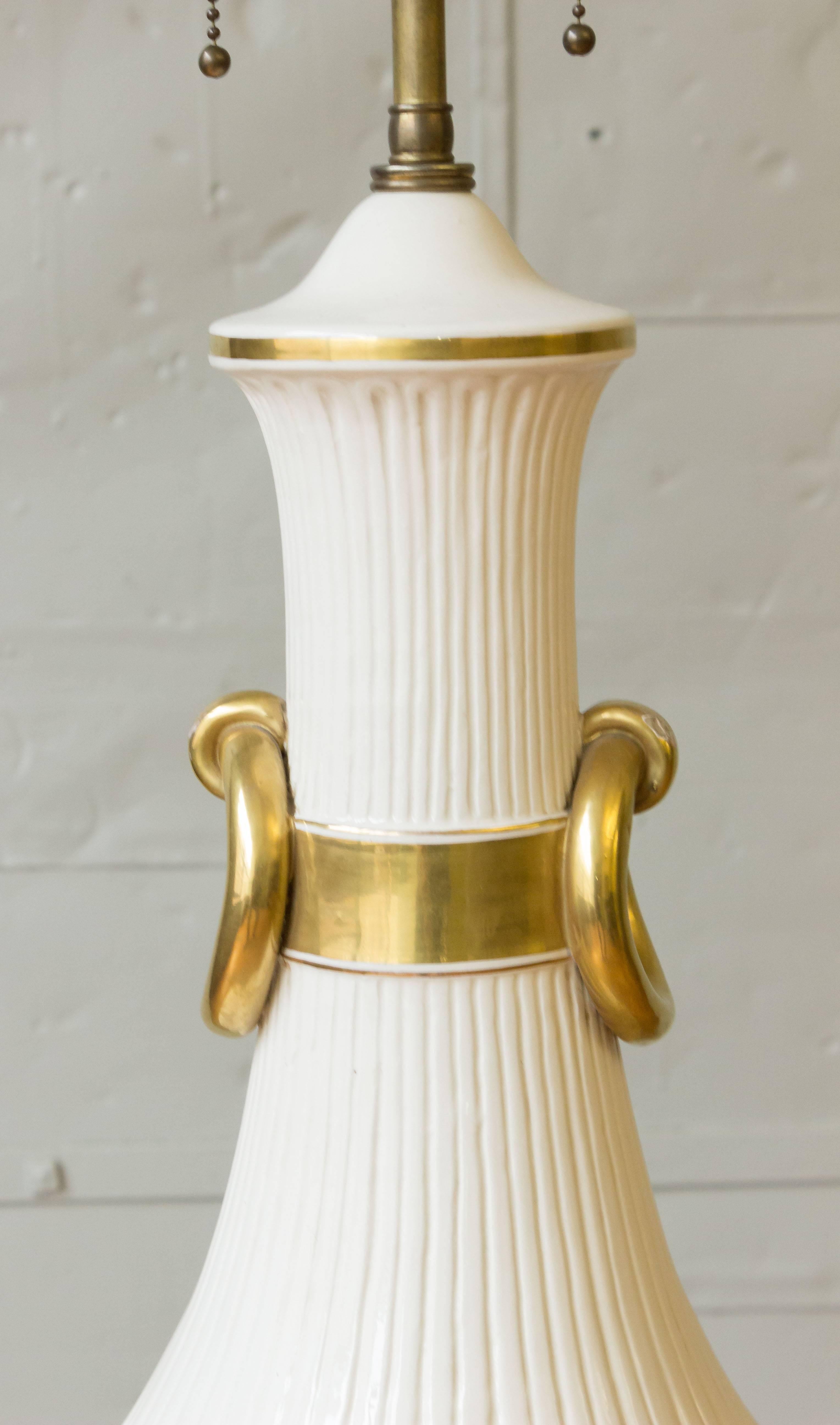 A very large French 1940s white soft-paste porcelain lamp with gold accents. This French lamp from the 1940s exudes elegance and sophistication with its very large, soft-paste porcelain body. Standing at an impressive 38 inches tall, it commands