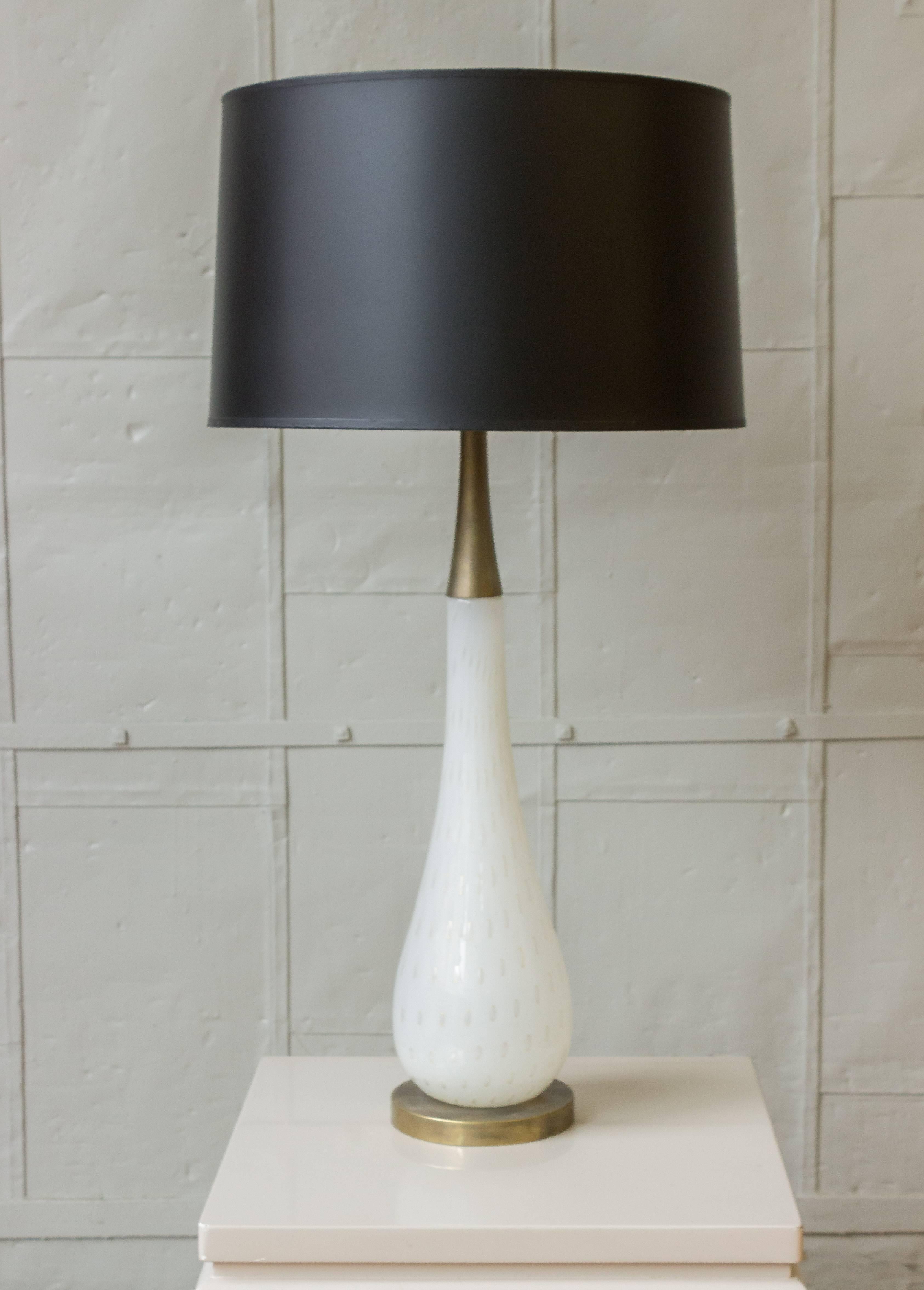 Very simple and elegant Italian Murano glass lamp. The handblown tear-shaped glass has inclusions throughout. The lamp is fitted on a richly patinated base and has a brass neck fitting and finial. Very good condition. Wired for showroom display.
