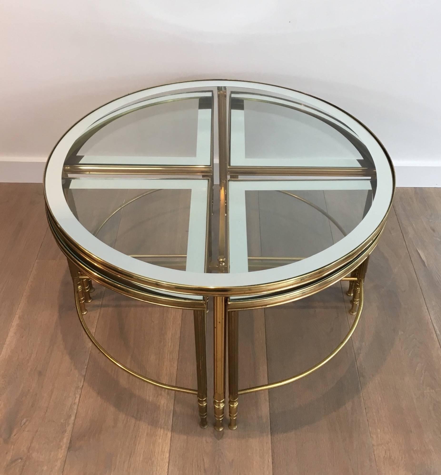 Beautiful round brass coffee table with four nesting tables that can be stored under the larger table. Glass tops with reversed mirror surrounds. In the style of Maison Jansen, French, circa 1960

These tables are currently in France, please allow