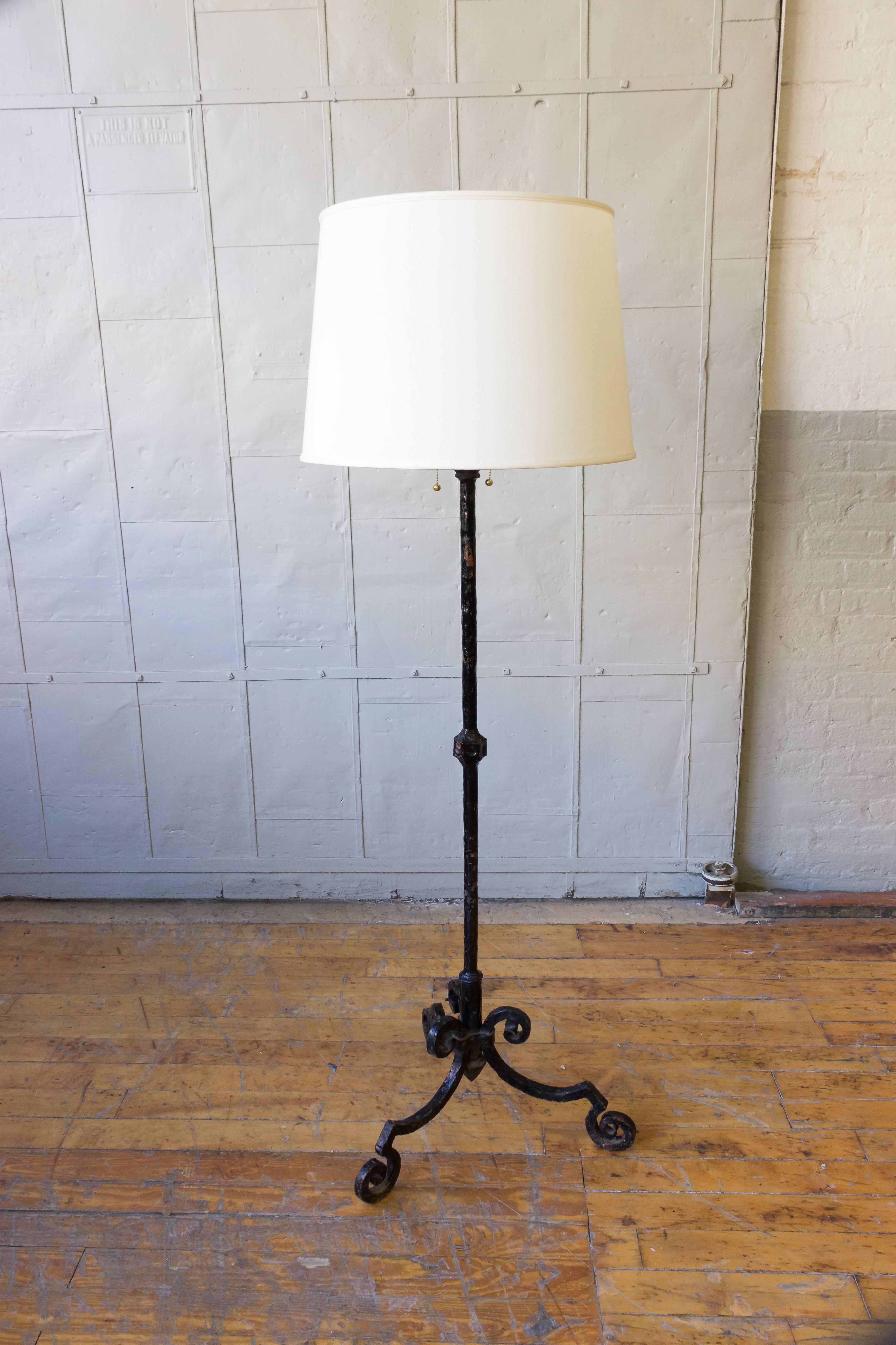 A large and heavy wrought iron floor lamp with a black painted finish. Spanish, 1950s. 

The price includes new wiring, not sold with shade (photographed with 18 inch H x 20 inch diameter shade).