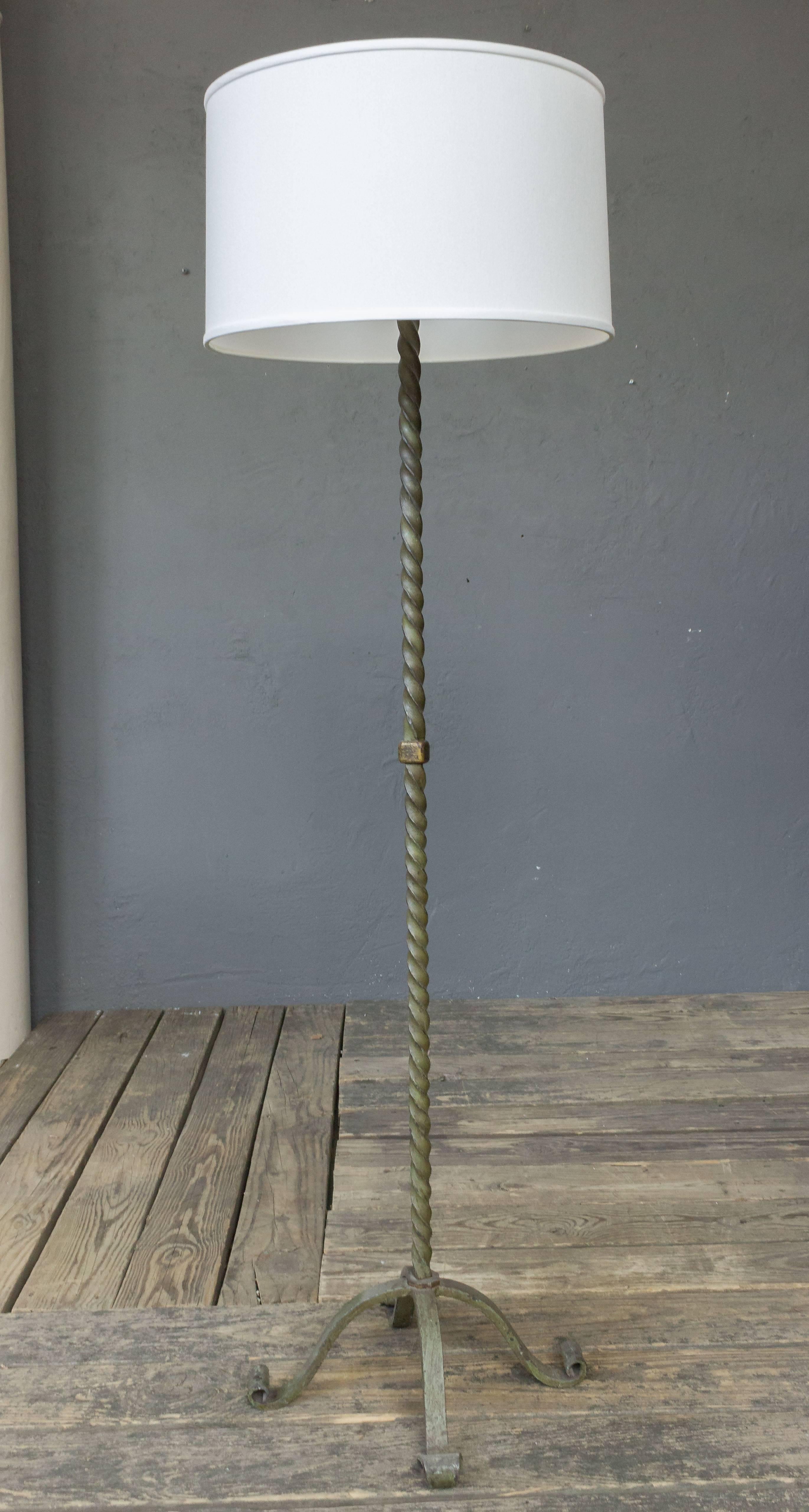 A good quality wrought iron floor lamp with original green patina. The solid stem is mounted on four footed base, French, 1920s. Price includes new wiring, not sold with shade.
 