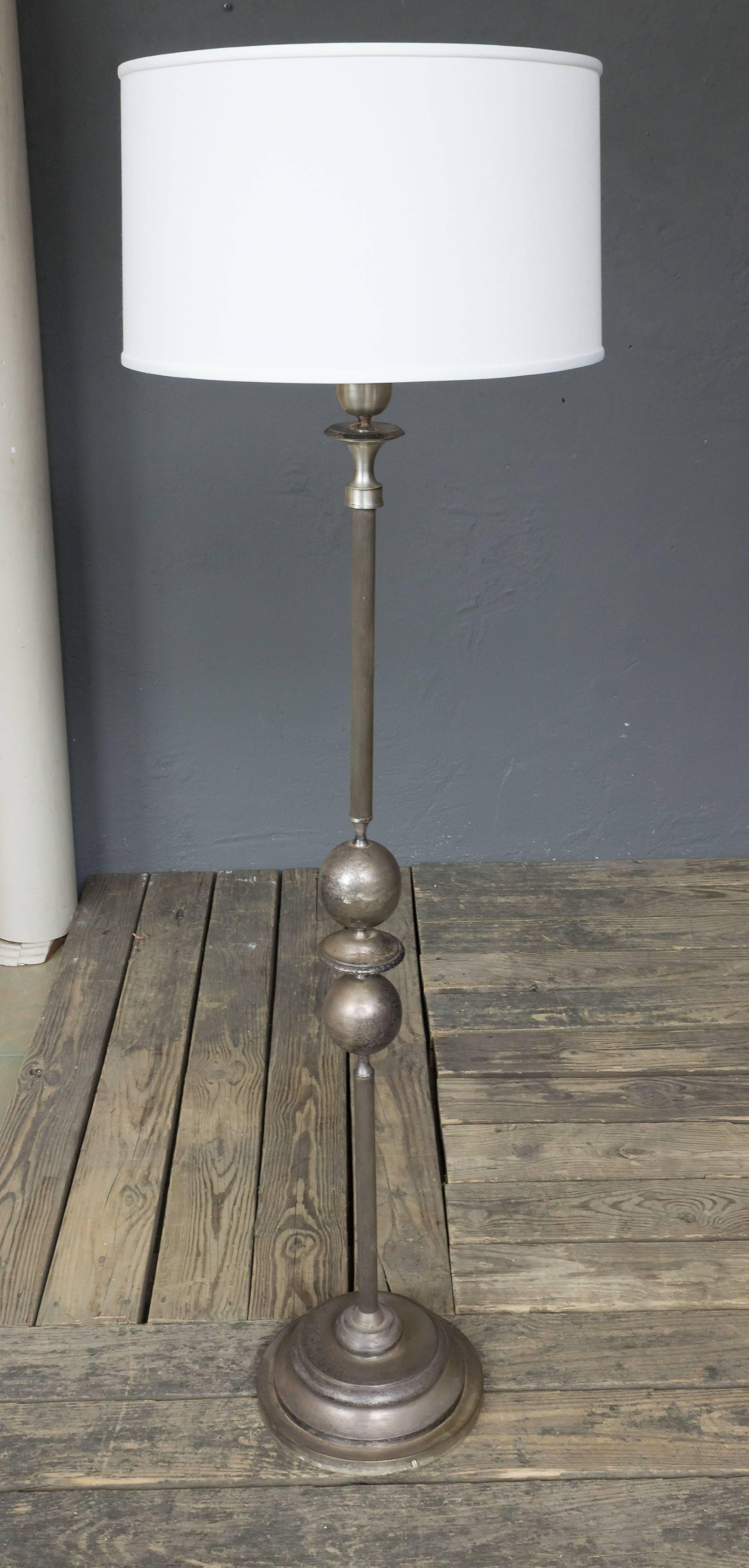 An unusual modernist floor lamp made of silvered brass and metal components having a series of spheres and discs joining the fluted stems. The floor lamp is supported on a stepped circular base. French, 1960s.

Price includes polishing or plating
