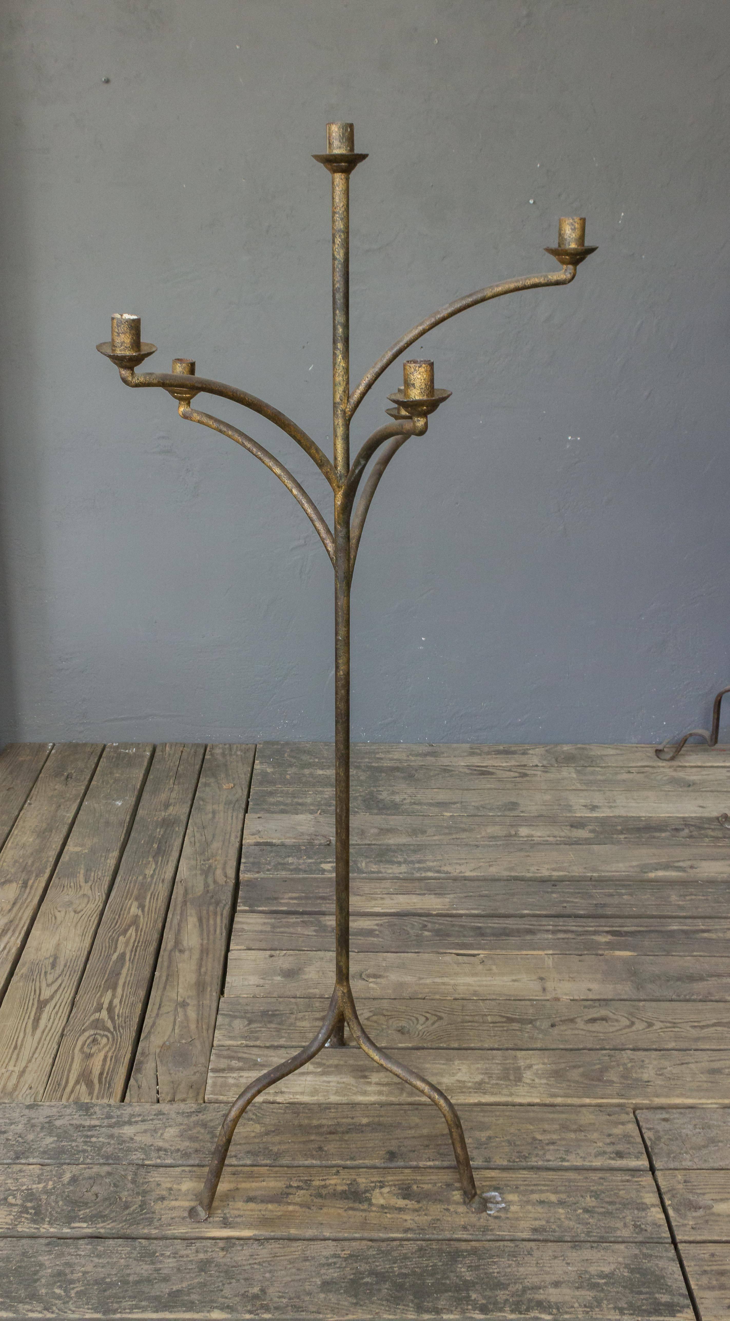 A very large gilt iron standing candle holder with five arms. Spanish, 1950s. This item can be wired as a floor lamp. Sold as is. 
