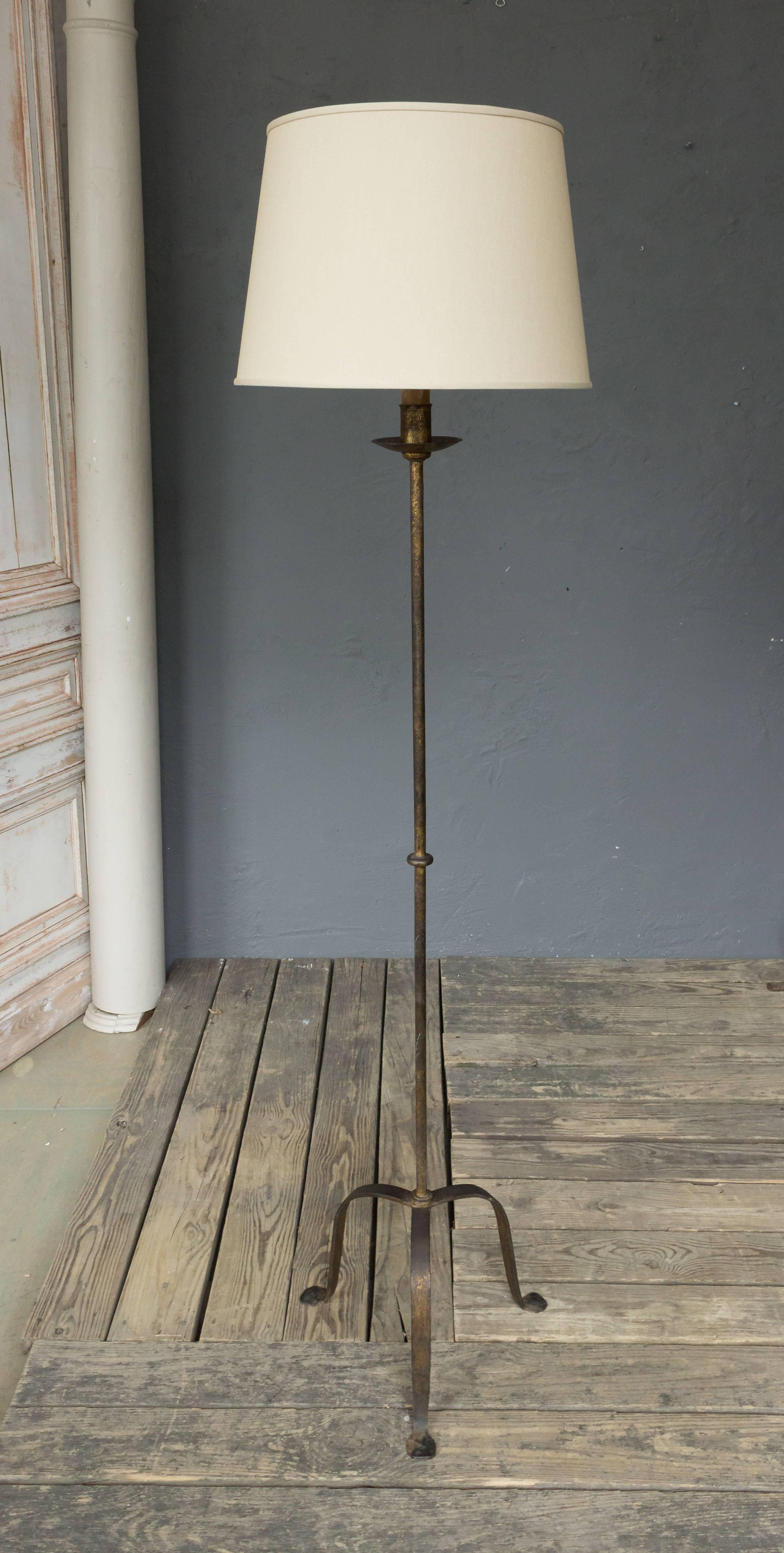 1940s Spanish Iron floor lamp with traces of gilt and patinated finish. Not sold with shade.