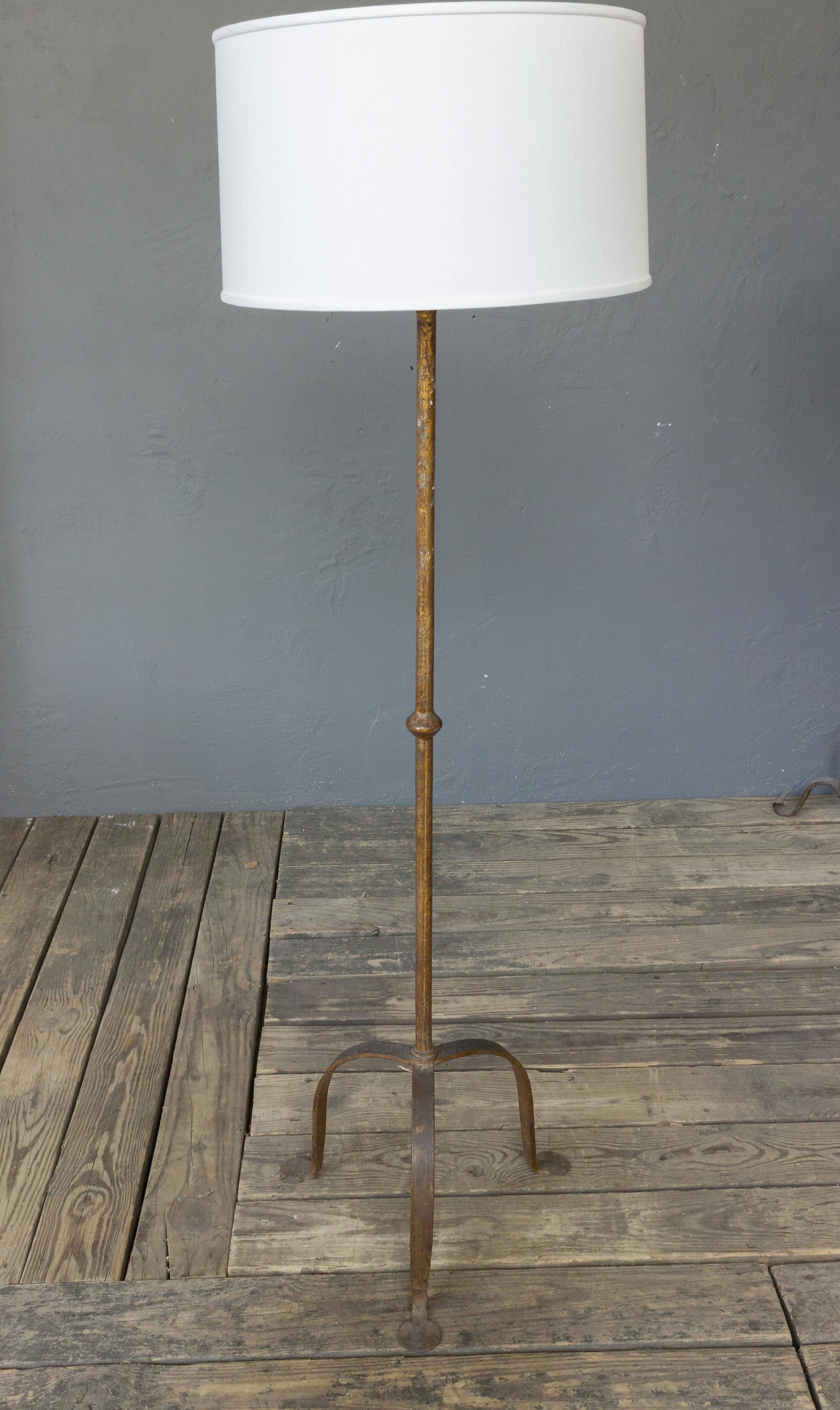 Spanish gilt iron floor lamp with tripod base, circa 1950s.  Recently rewired, sold in good vintage condition. The lamp has a rich dark gold patina. 

Not sold with shade.