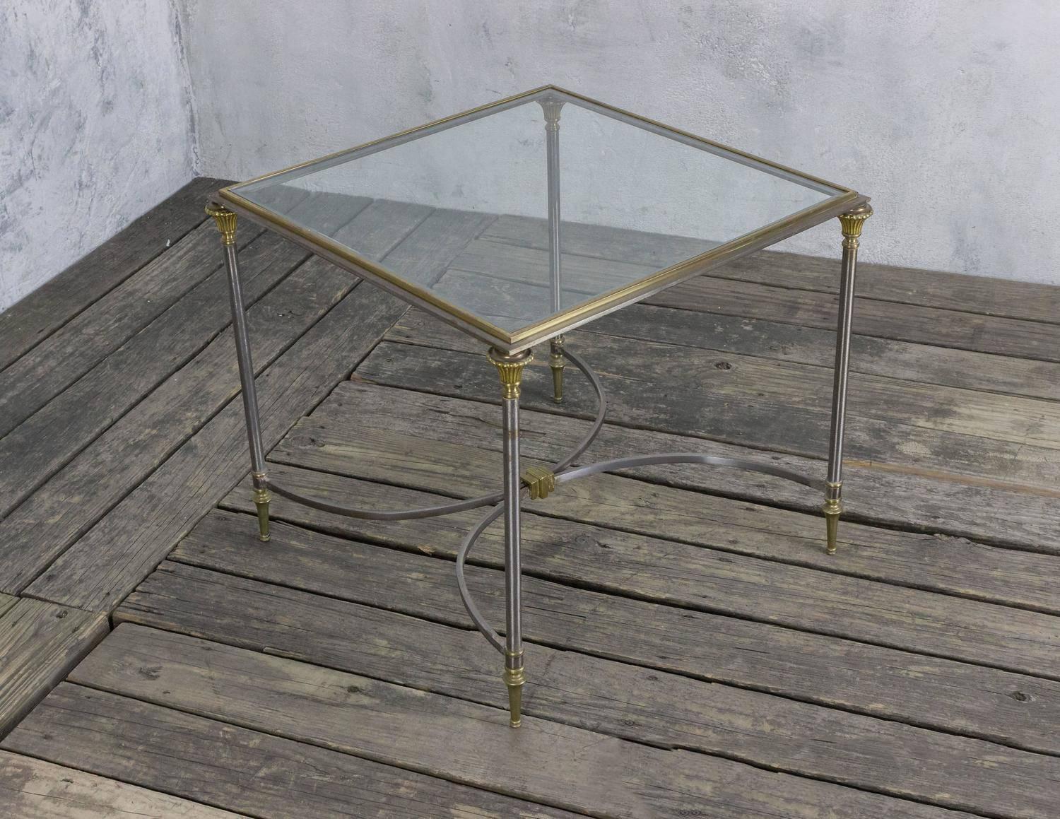 Polished steel coffee table with brass highlights with inset glass top and center stretcher, French 1960s, Maison Jansen.