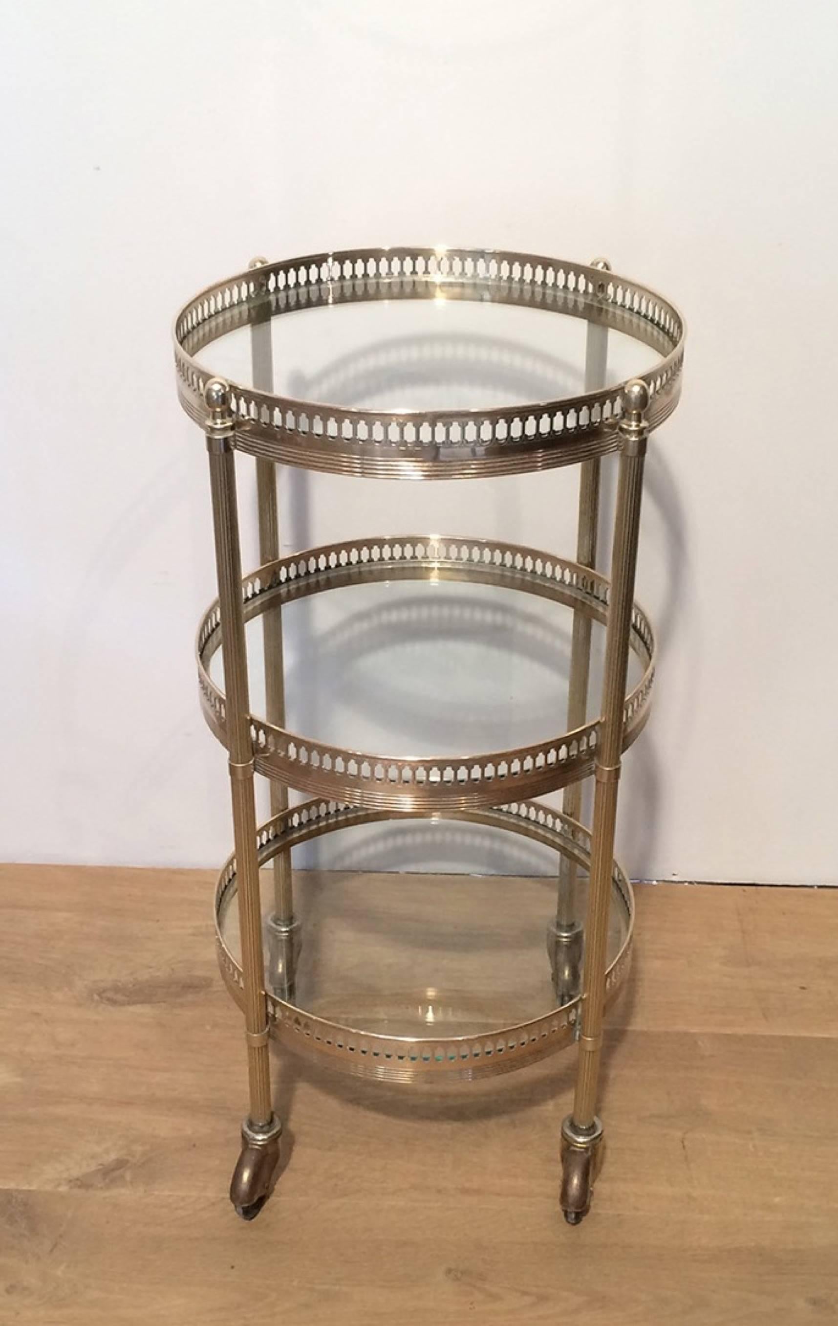 Small round brass drinks table or bar cart with three glass shelves. French, circa 1940

This table is currently in France. Please allow 4 to 6 weeks delivery, price includes delivery to our warehouse in Long Island City, NY.
 