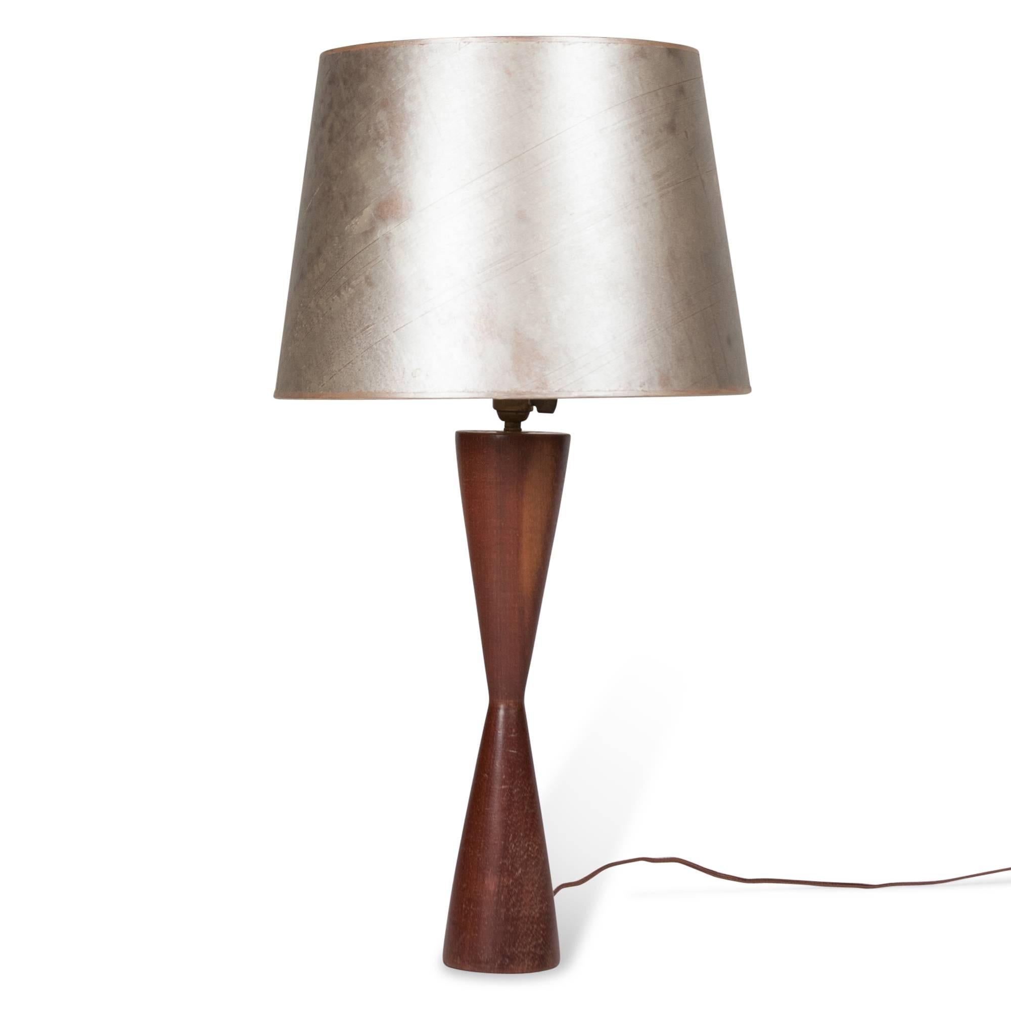 Turned walnut table lamp, in double cone form, one of which is inverted, Danish, 1950s. In silvered paper shade. Measures: 3.5” D base, 14.25” D shade at widest, 27” H. (Item #3311)