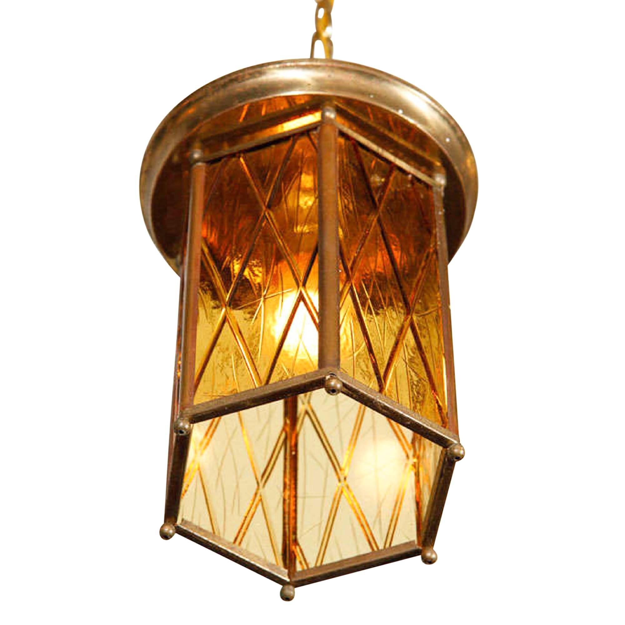 Hanging lamp, the shade composed of amber tinted glass with cross-hatch pattern, set into a bronze frame, Germany, 1920s. Suspended by a chain from the ceiling canopy. Width of fixture 7 inches, height of fixture 8 1/4 in. 