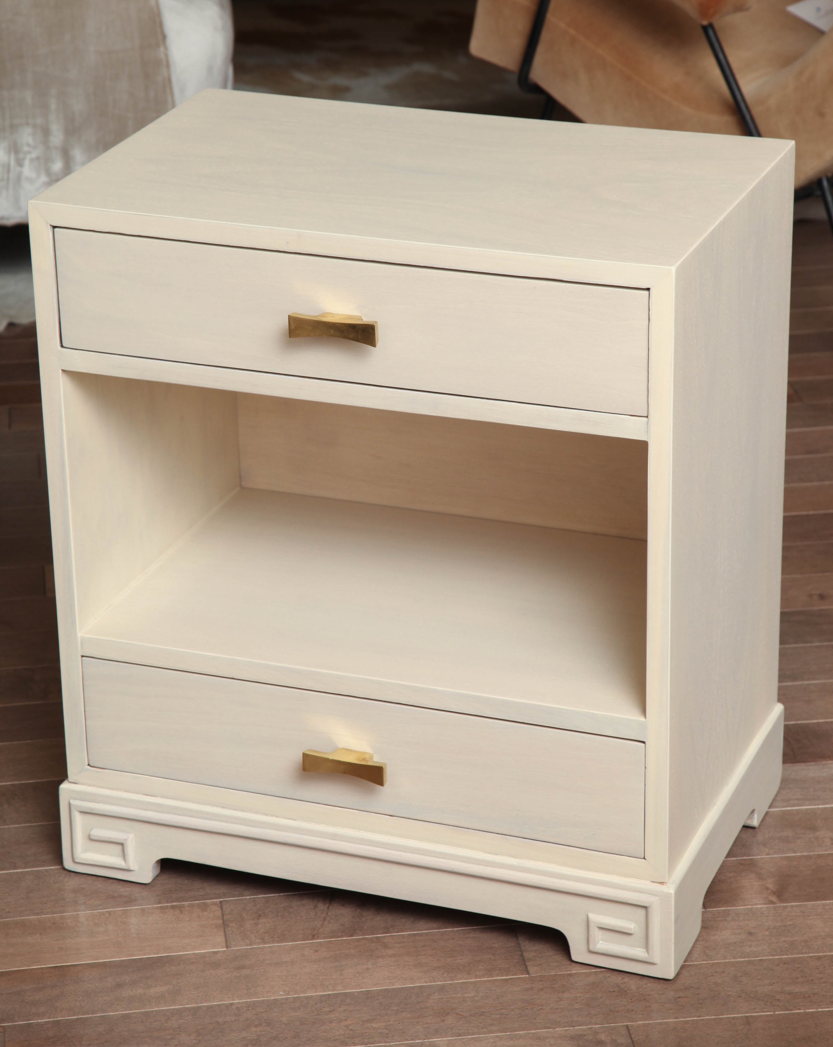 Pair of white washed bedside tables with two drawers and open center shelf. Featuring brass statement hardware, circa 1960.