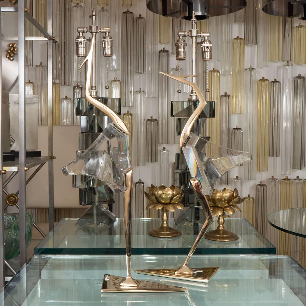 Pair of stylized Lucite and brass crane sculptures.