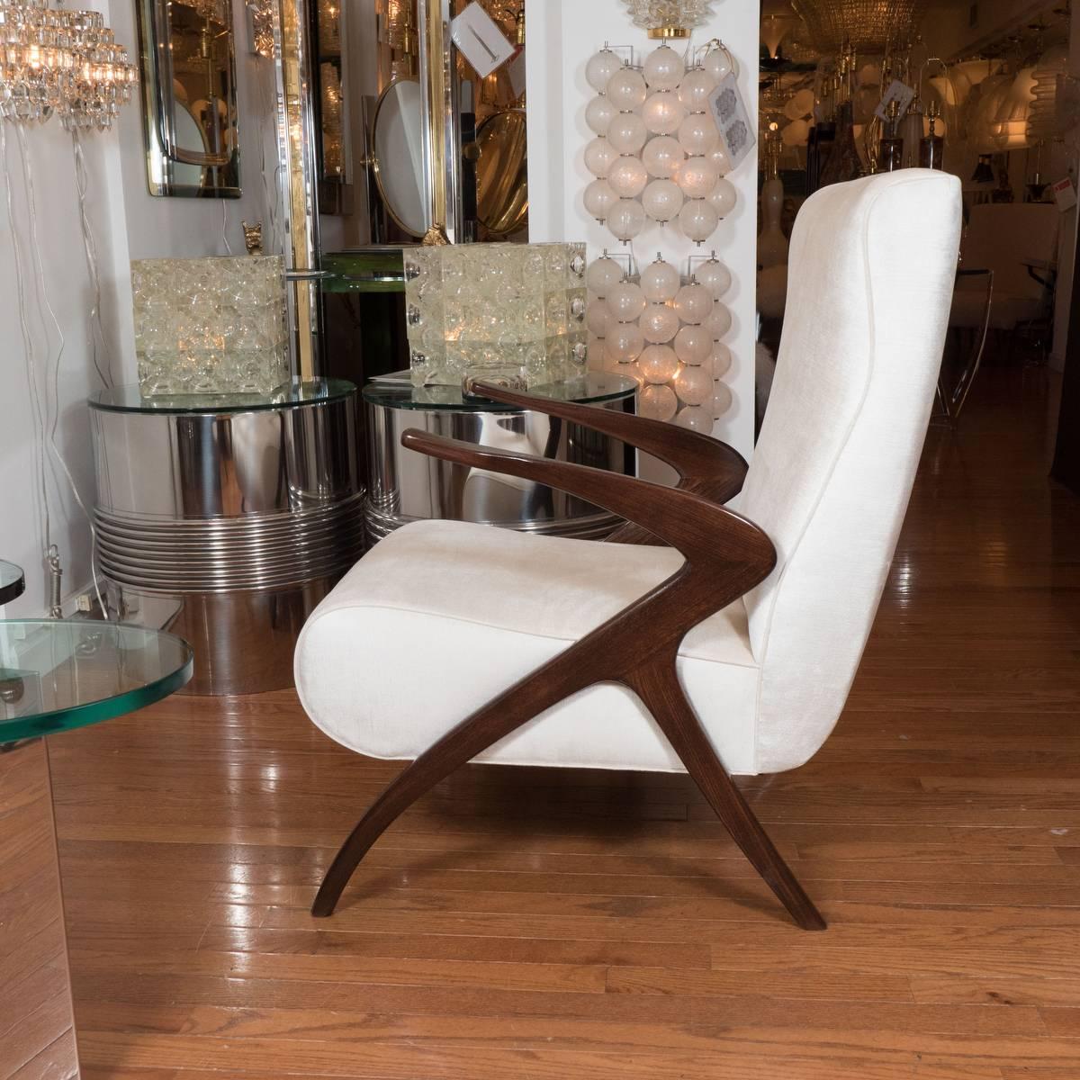Pair of highly stylized armchairs with mahogany finish and angular design.