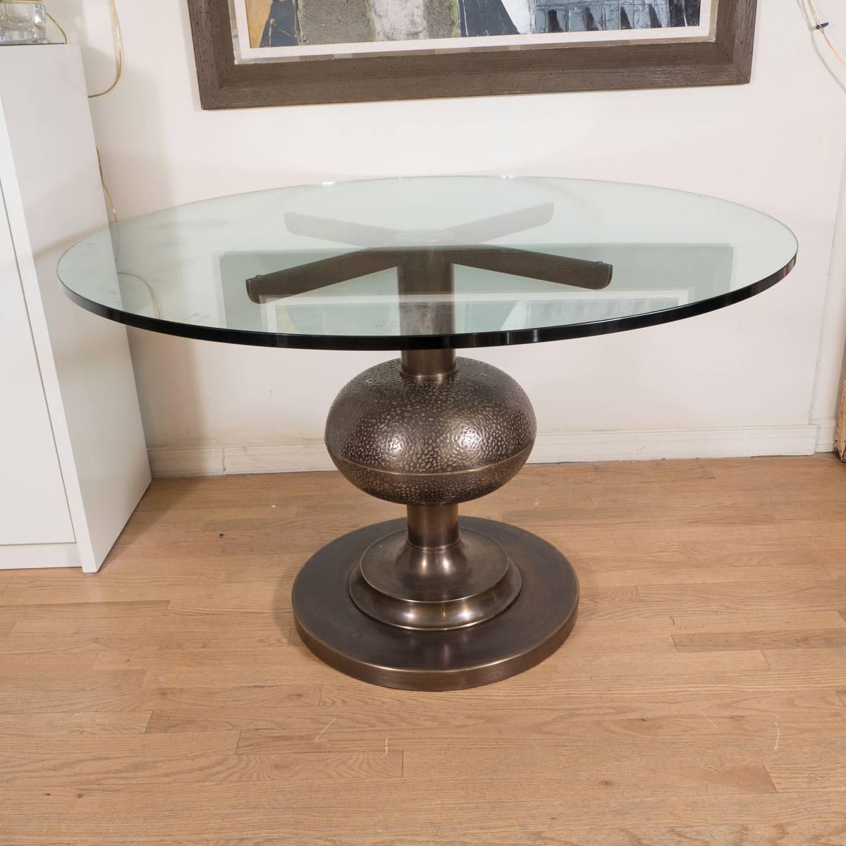 Circular patinated and repoussed bronze center or dining table with glass top by Frigerio.