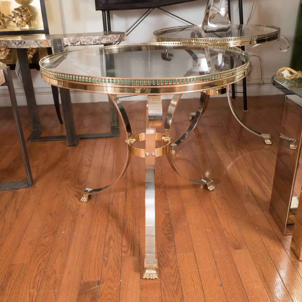 Pair of polished nickel and brass tripod tables with pierced galley edge.
