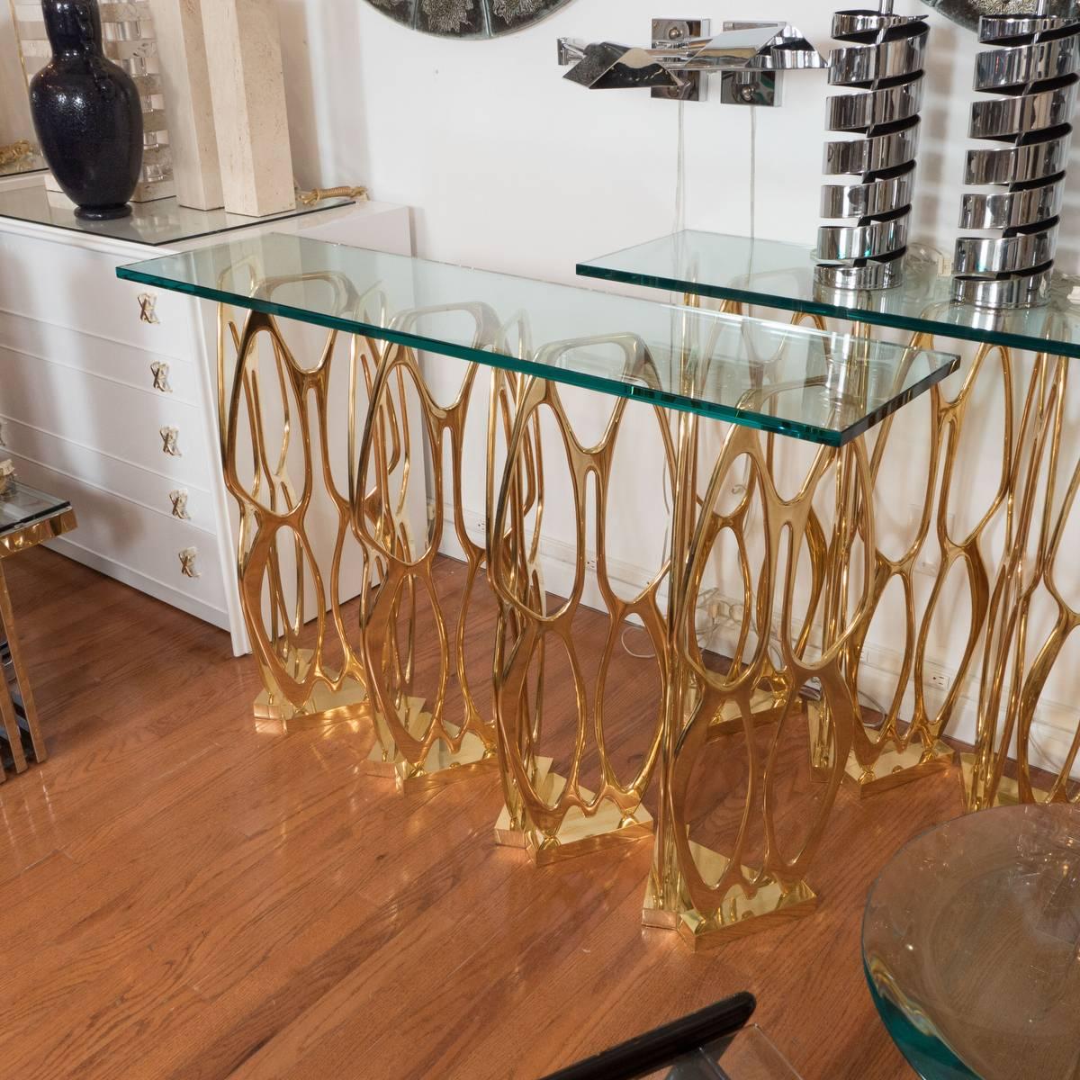 Sculptural console table composed of free-standing, brass openwork base elements.