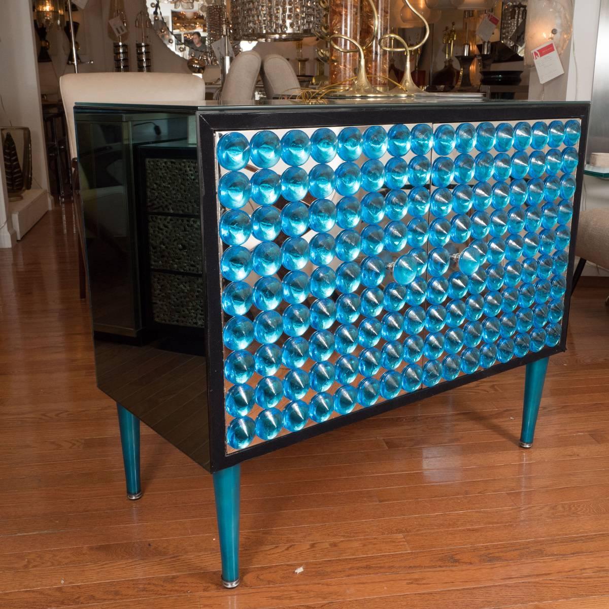 Lacquered wood and blue mirrored cabinet with applied glass element design on doors.