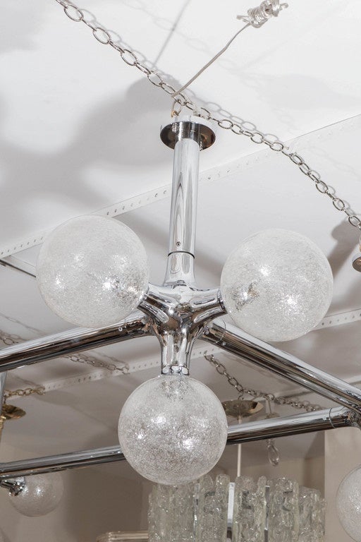 Large chrome grid form chandelier featuring twelve clear glass globes with inclusive air bubbles.