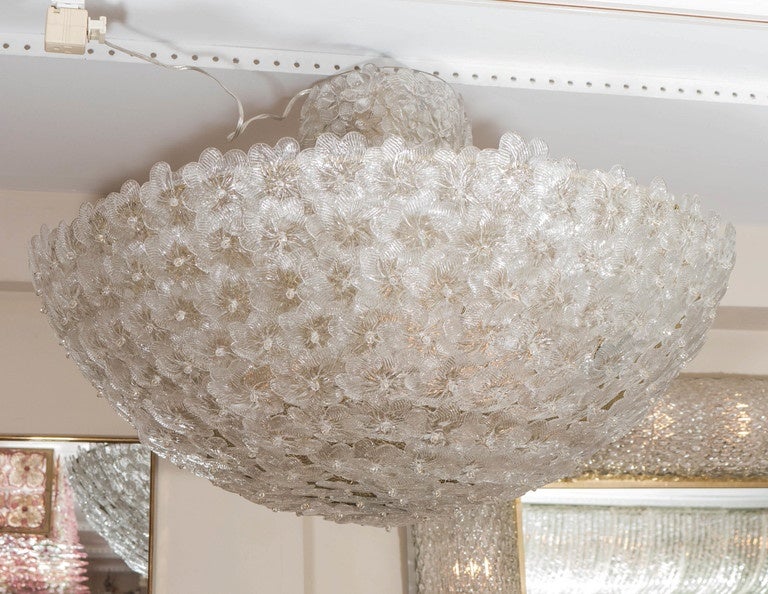 Dome form ceiling fixture composed of multiple clear and frosted glass flowers with flowered stem.