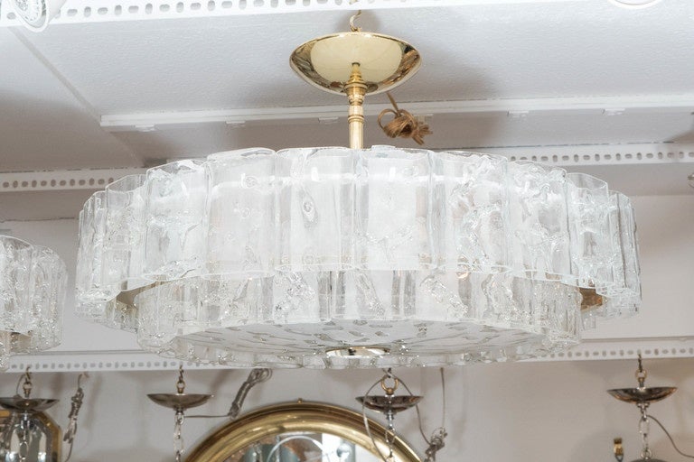 Two-tier brass chandeliers composed of multiple molded glass elements attributed to Doria.